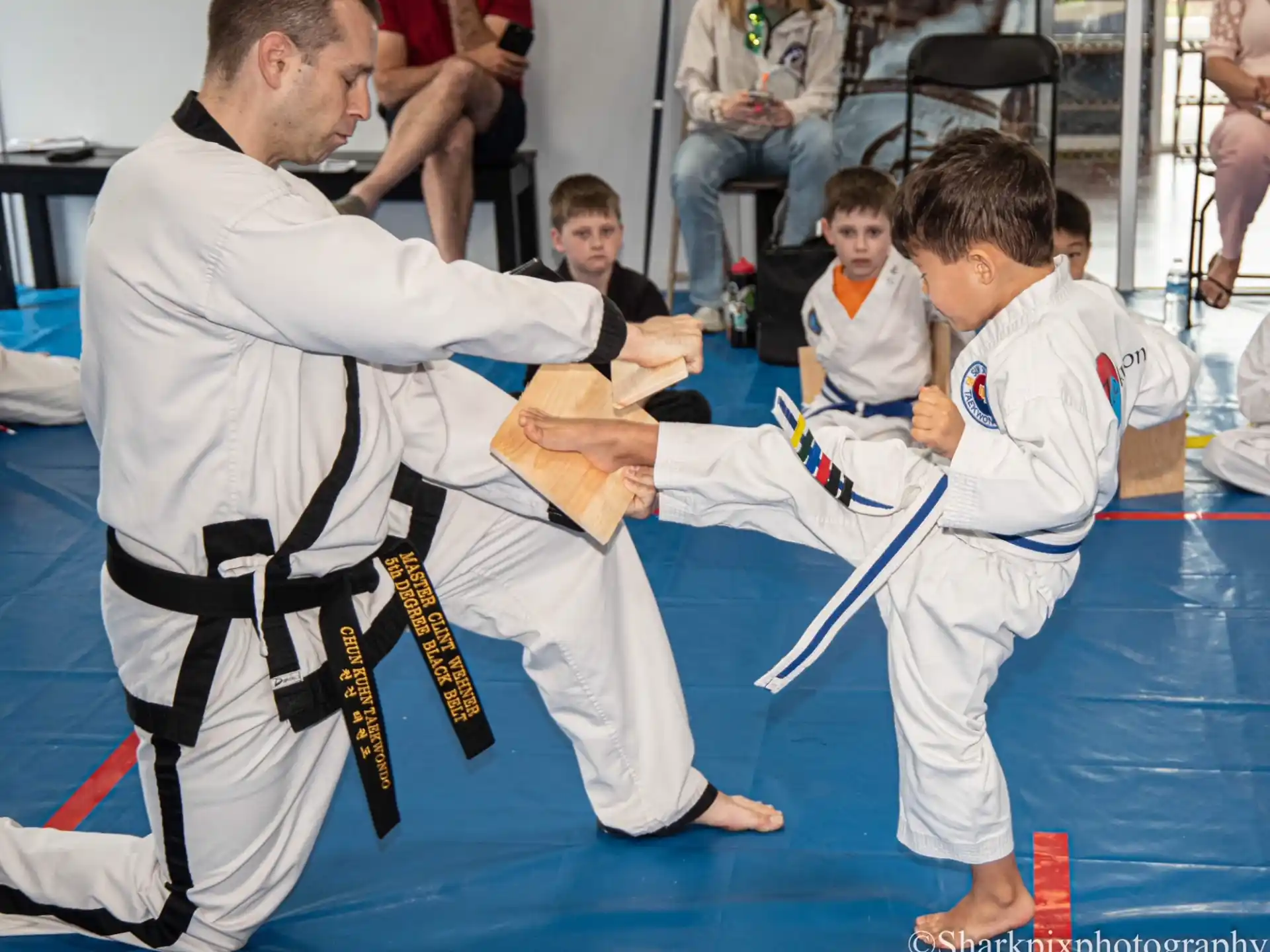 a person and a boy in karate uniforms with a person in the front