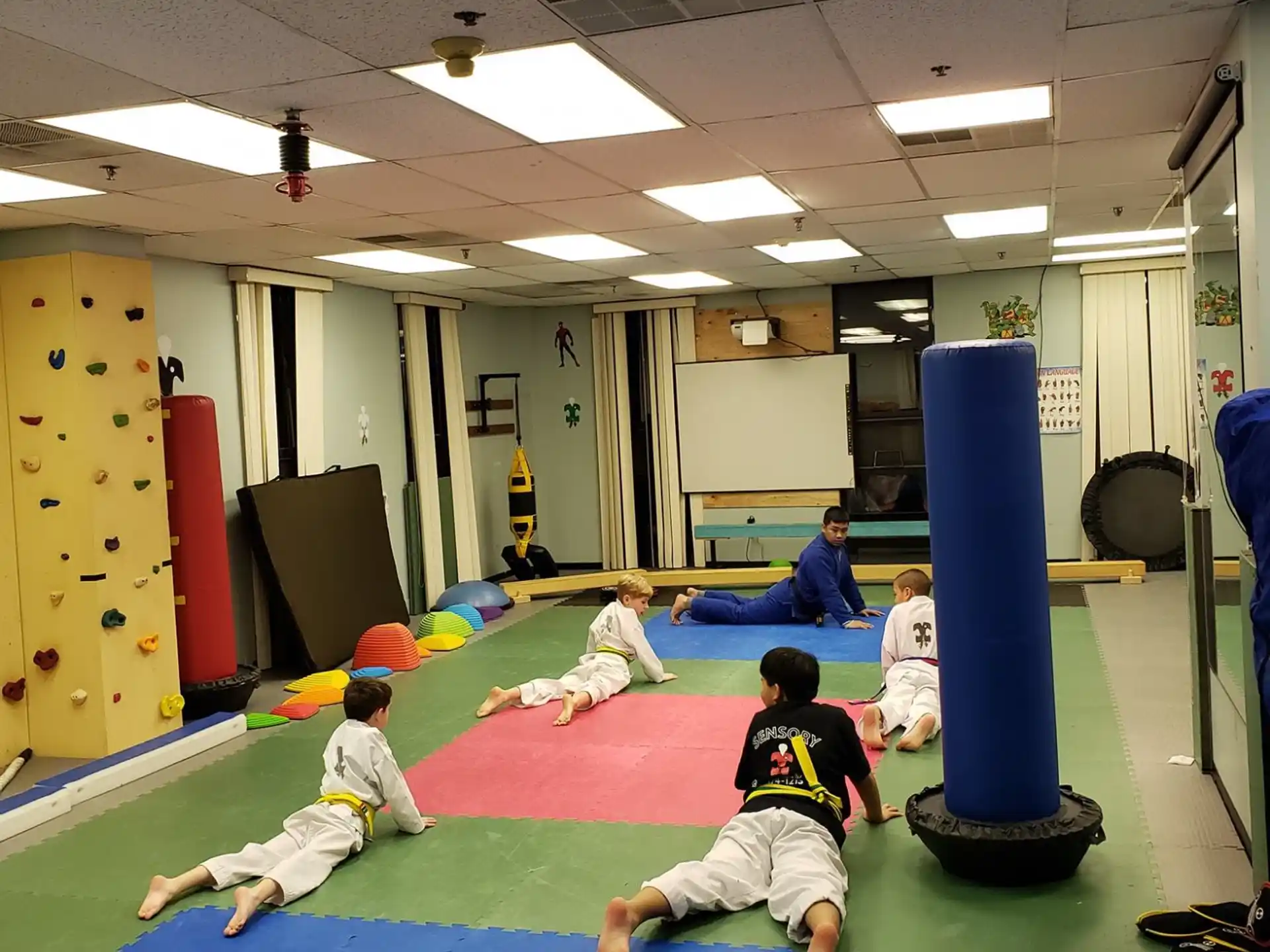 a group of kids playing on a mat in a room