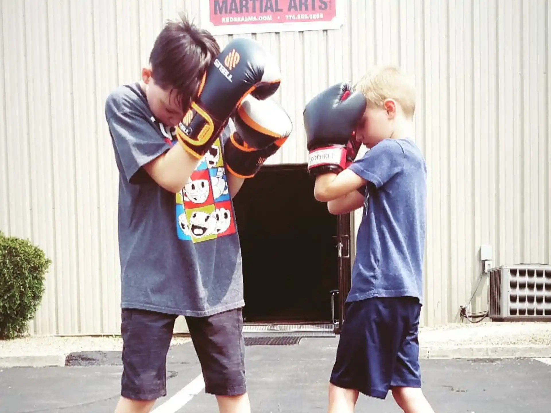 a couple of kids wearing boxing gloves