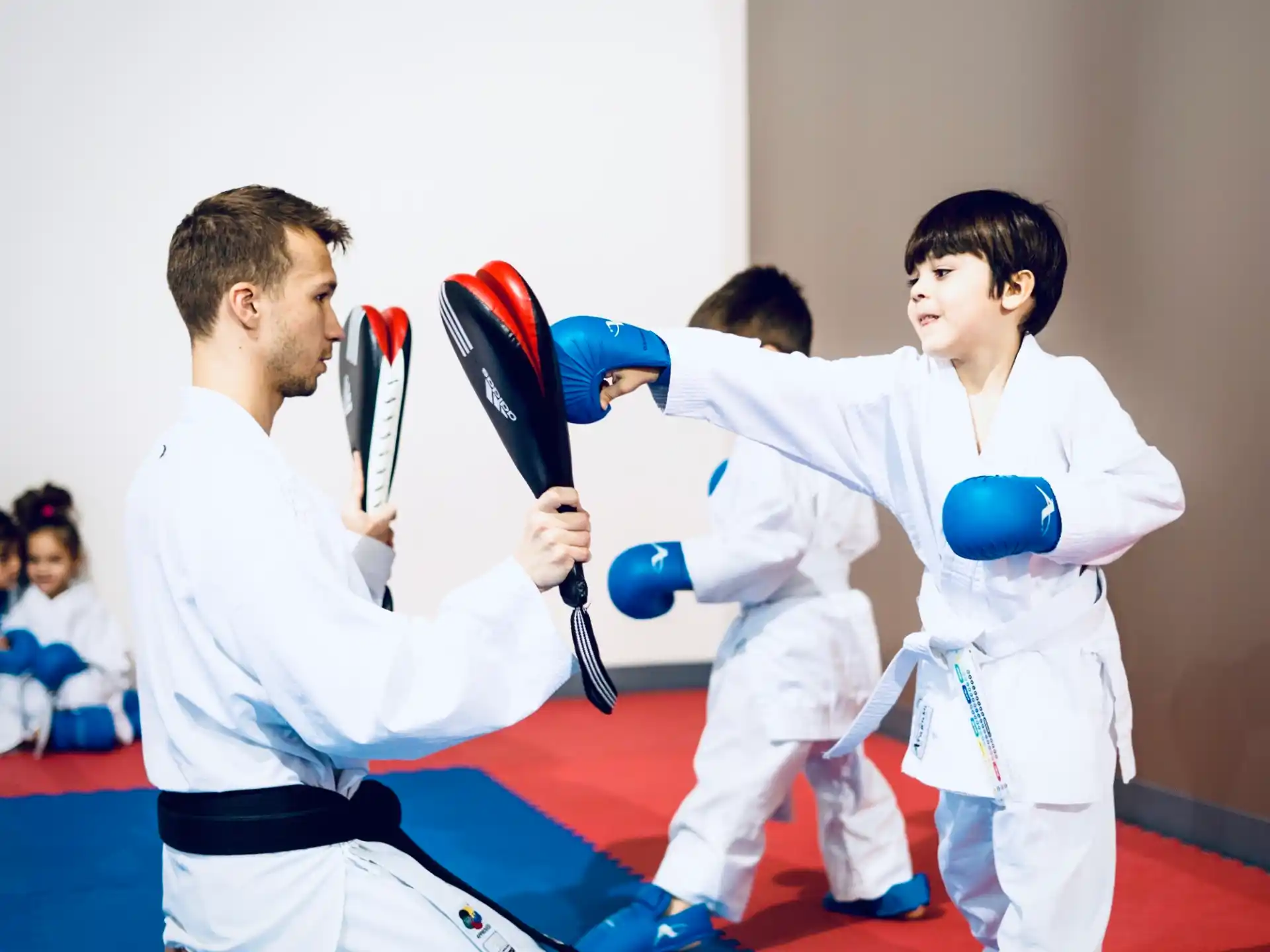 a man and a woman in karate uniforms holding swords