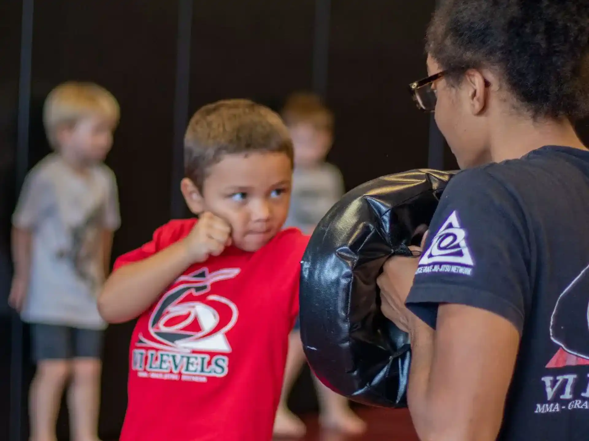 a person holding a helmet to a boy's head