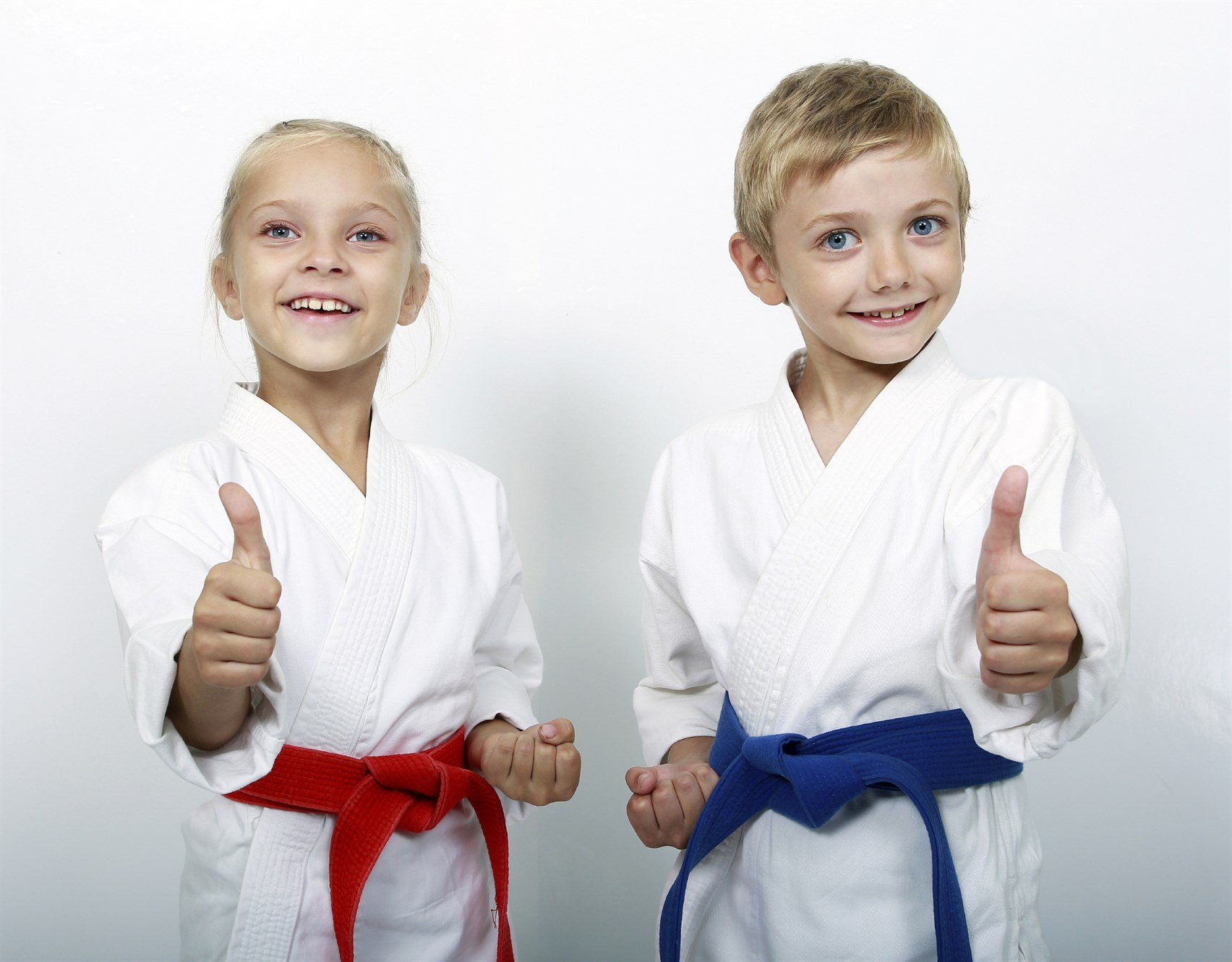 a couple of girls in white karate uniforms