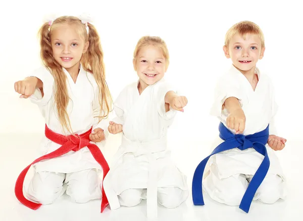a group of children in white clothes