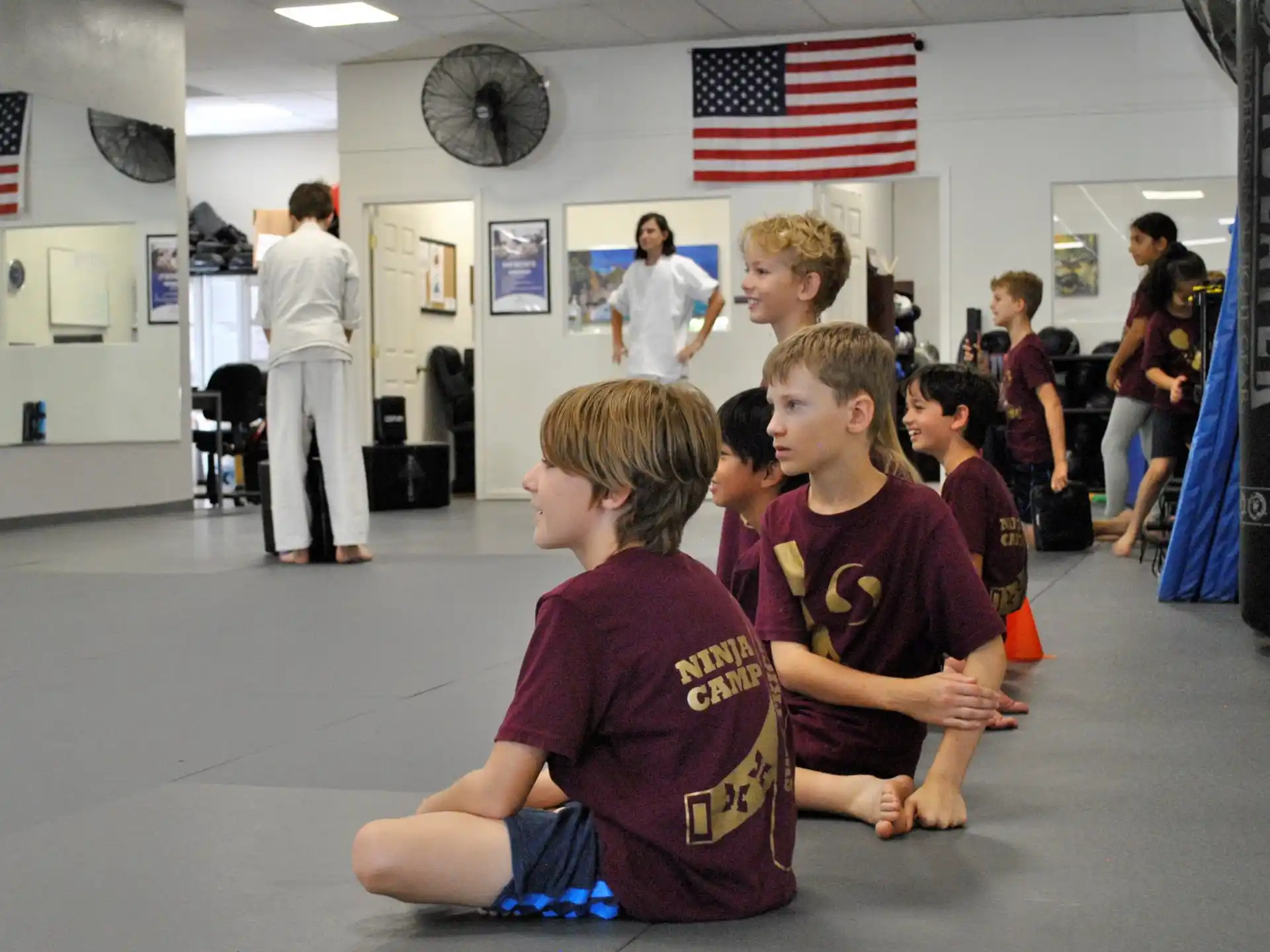a group of boys sitting in a room with a flag on the wall