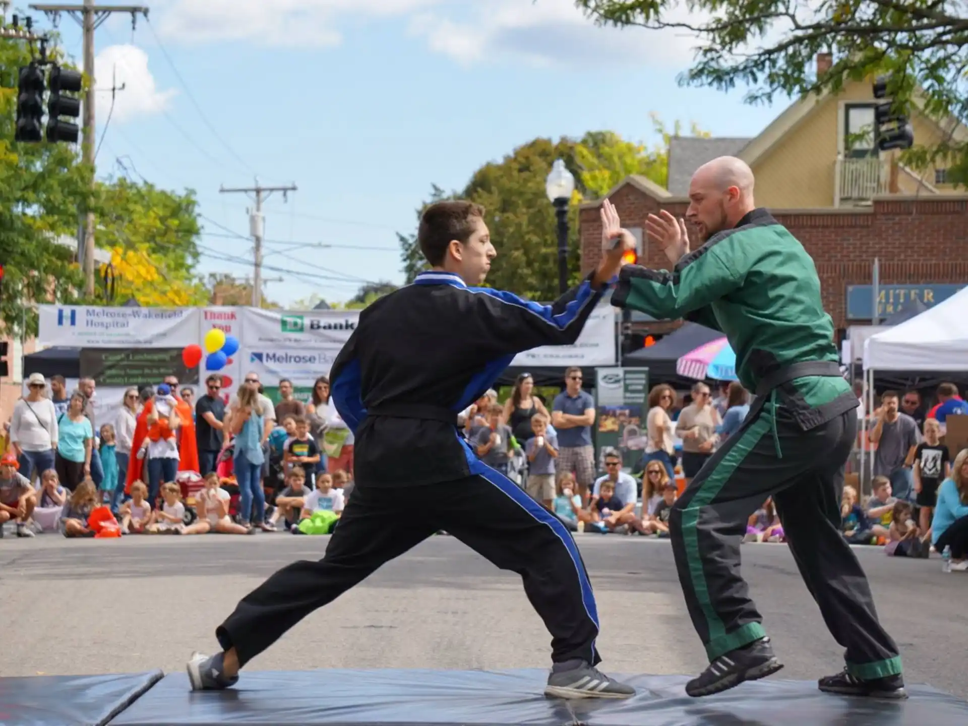 a person kicking another man in the face with a crowd watching