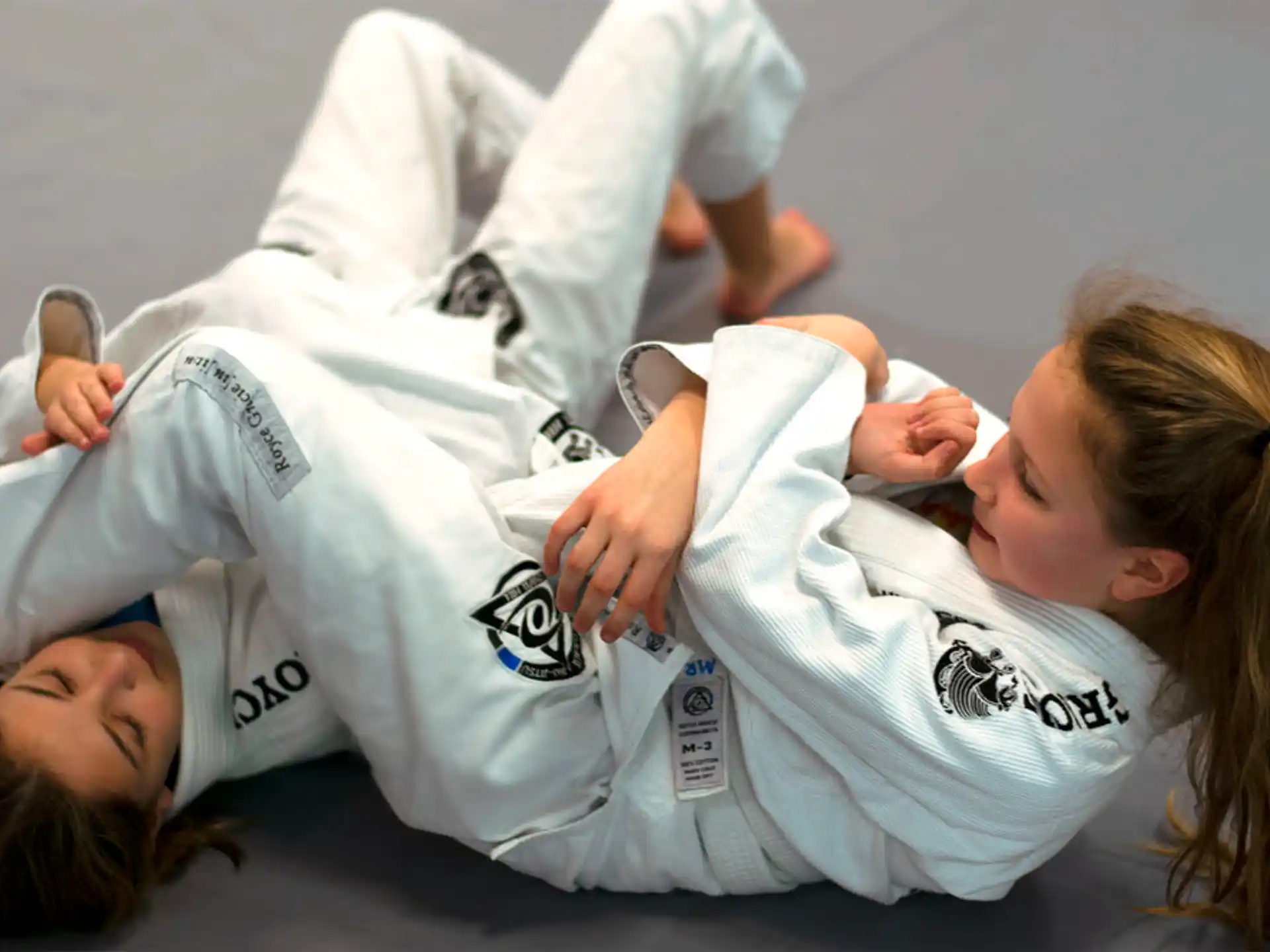 a woman lying on the ground with a man lying on her back