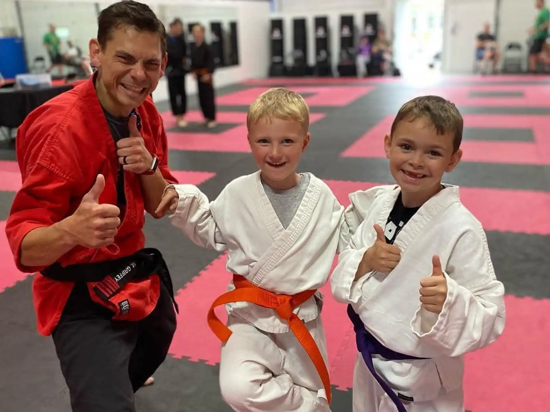 a person and two boys in karate uniforms