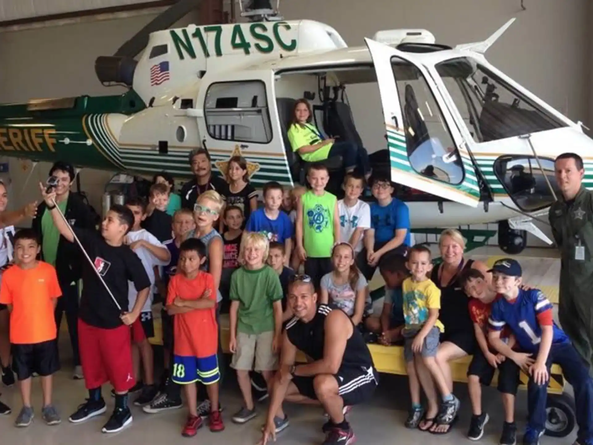a group of people posing for a photo in front of a helicopter