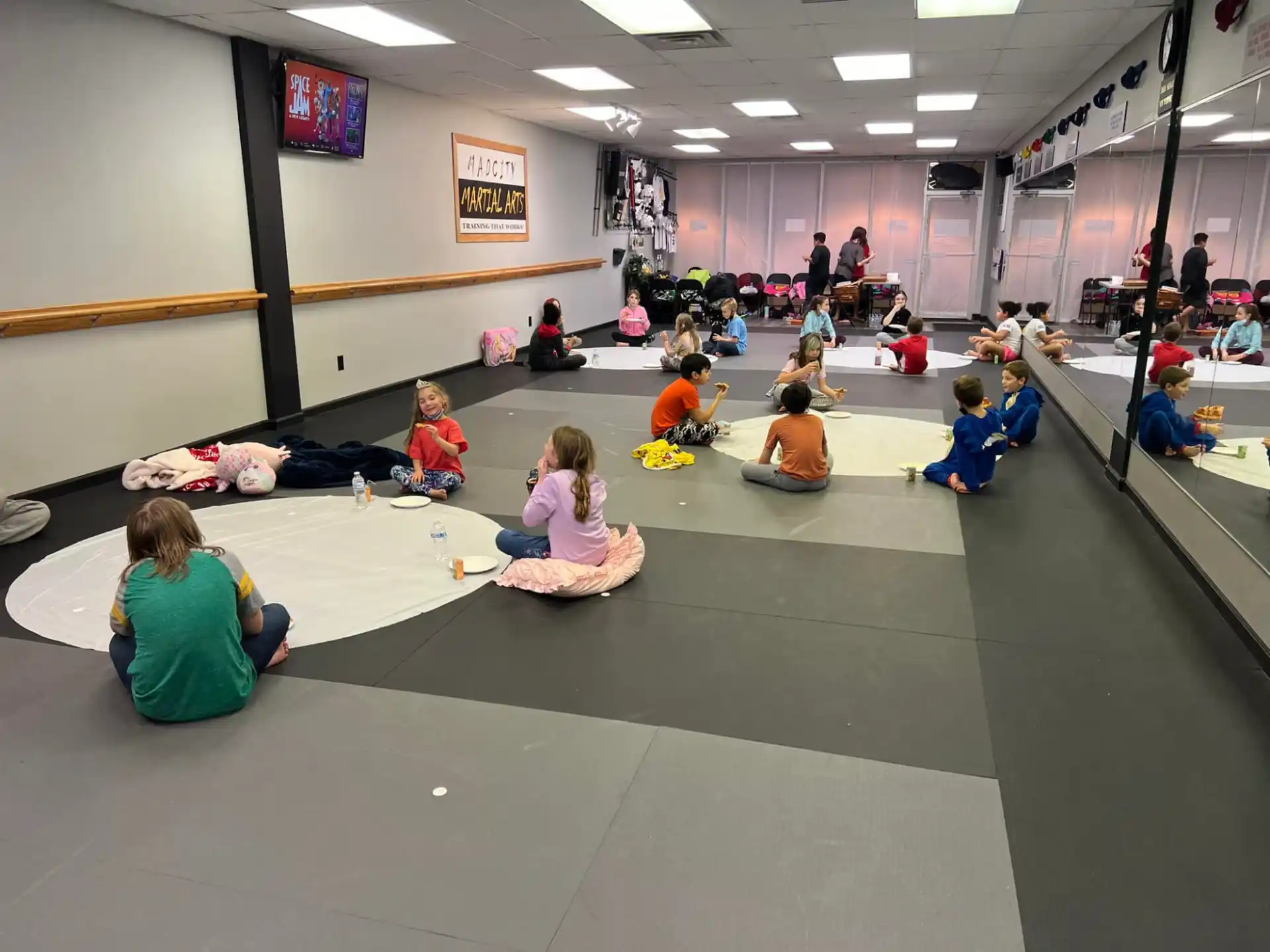 a group of people sitting on mats in a room