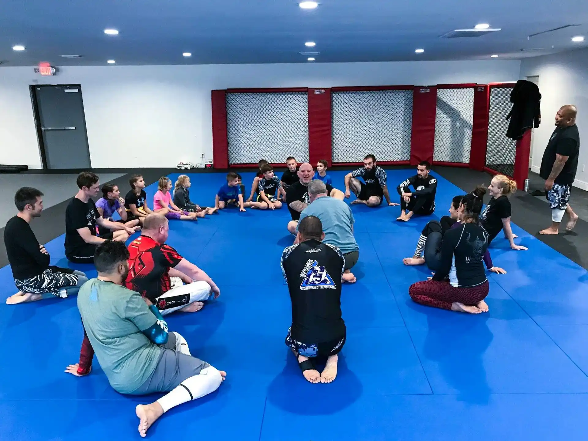 a group of people sitting on mats in a room with a blue floor