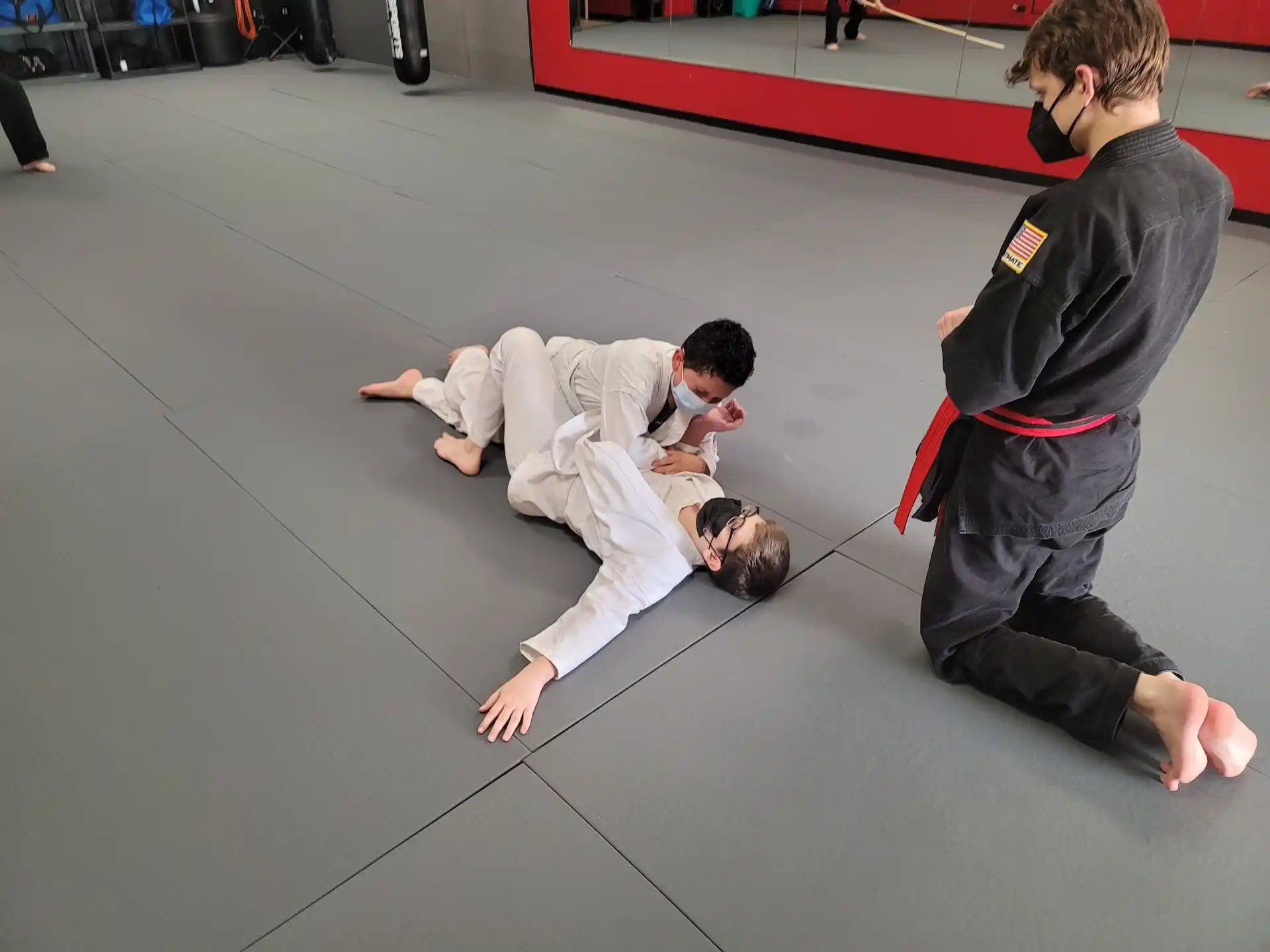 a person in a karate uniform kicking another man in the face
