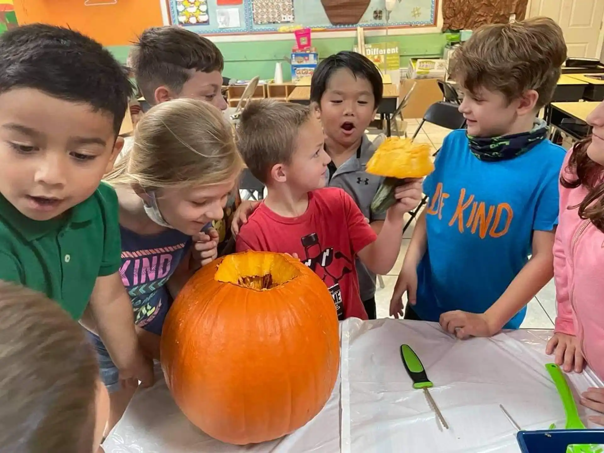 a group of children around a pumpkin