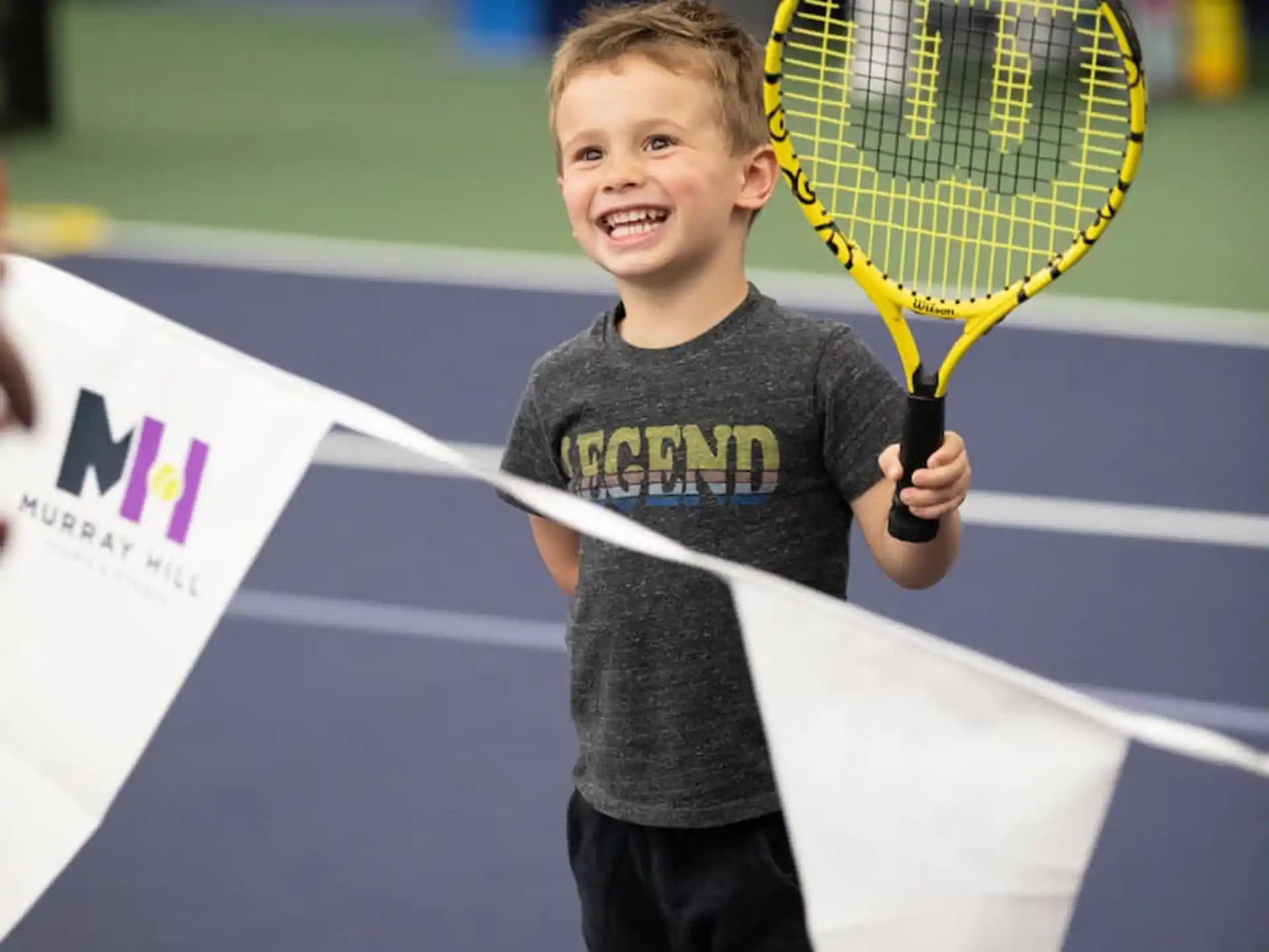 a boy holding a tennis racket