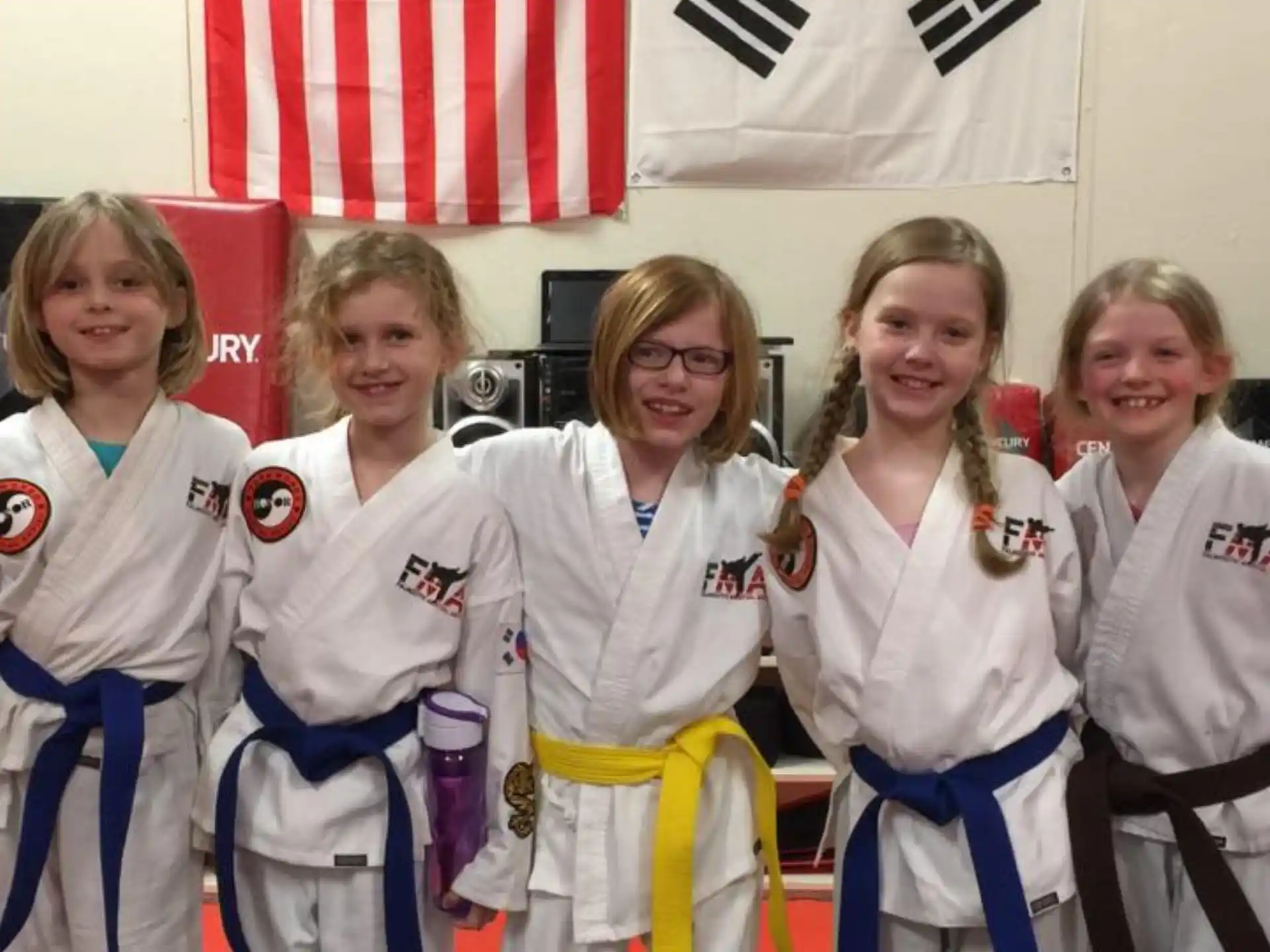 a group of women in white karate uniforms