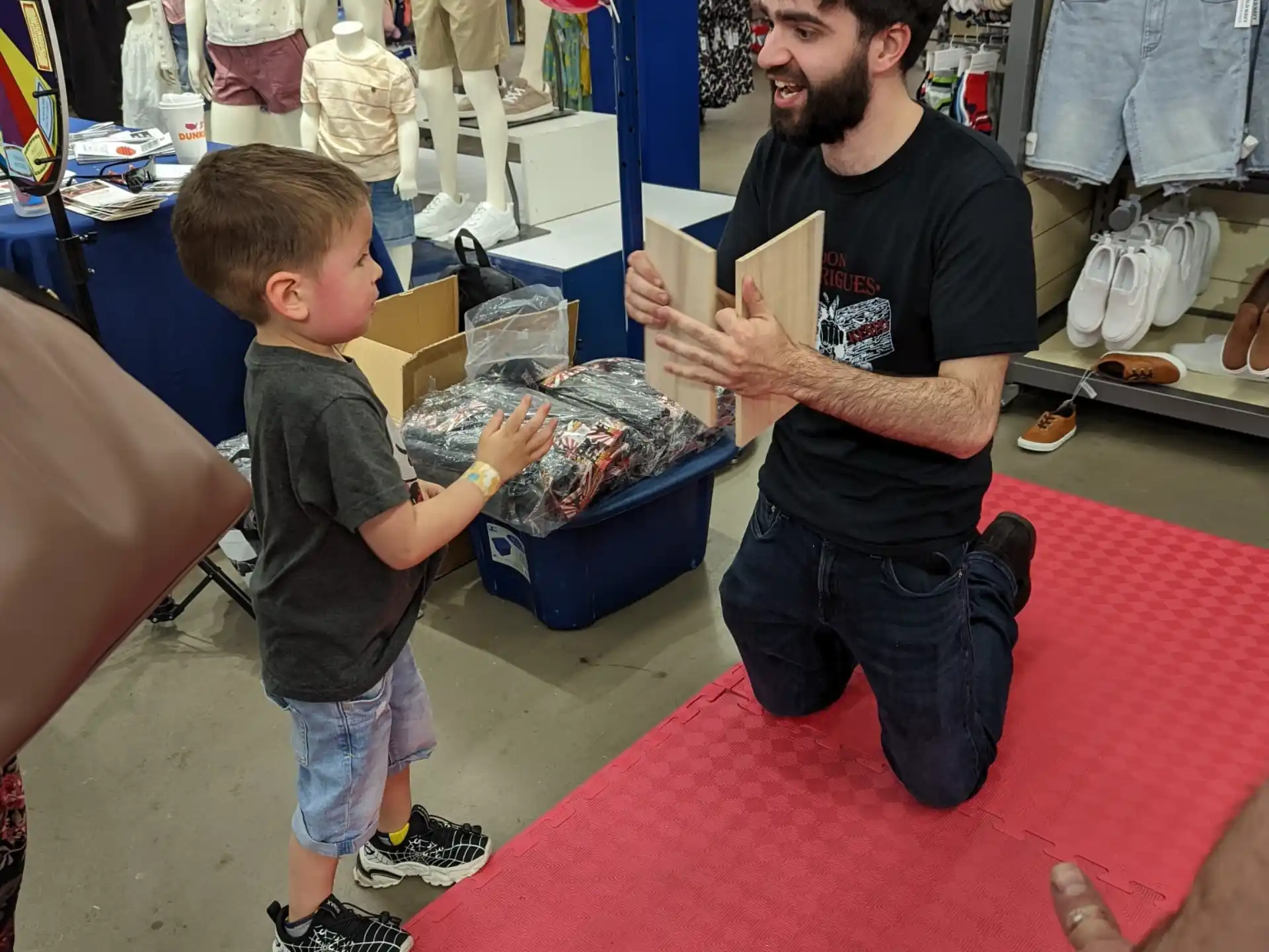 a person and a boy in a store with a box of cookies