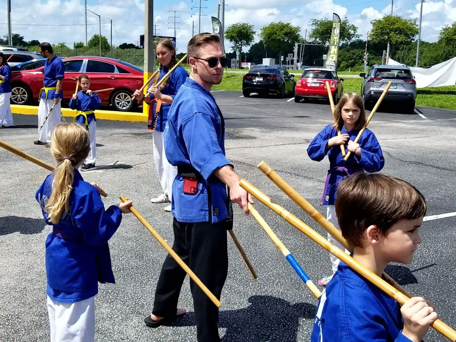 a group of people holding yellow sticks