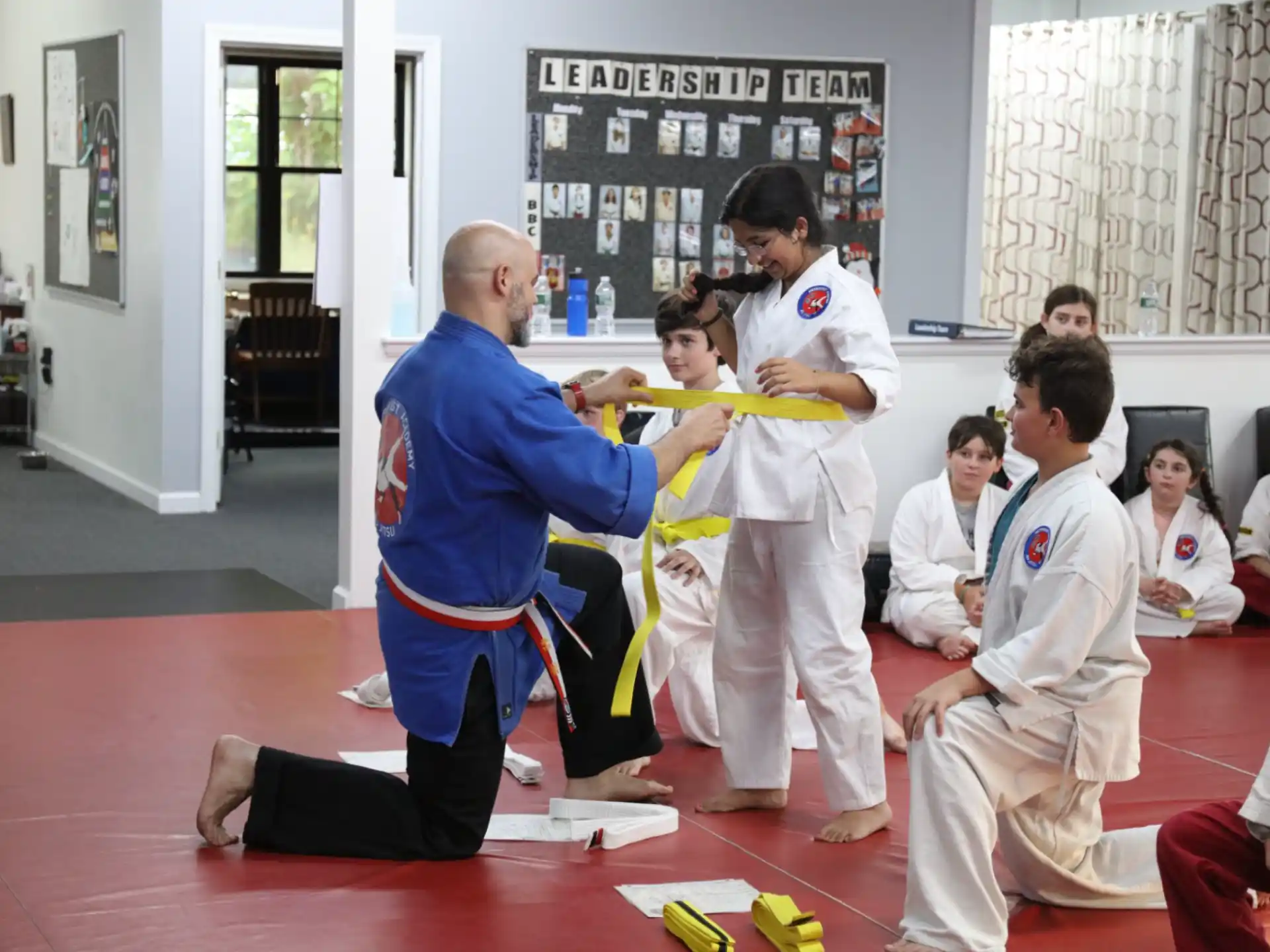 a person in a karate uniform being hugged by a group of people