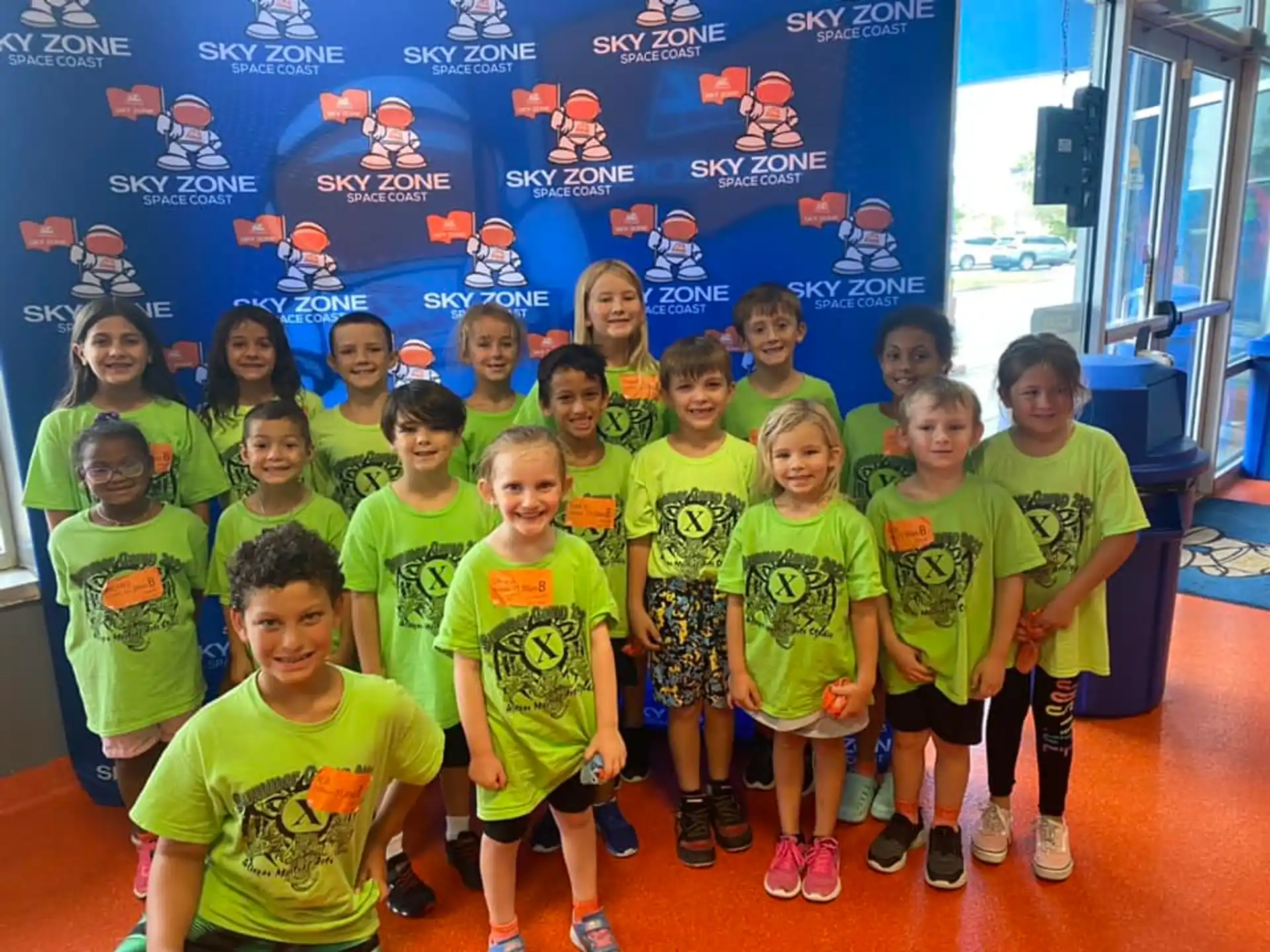 a group of children in green shirts