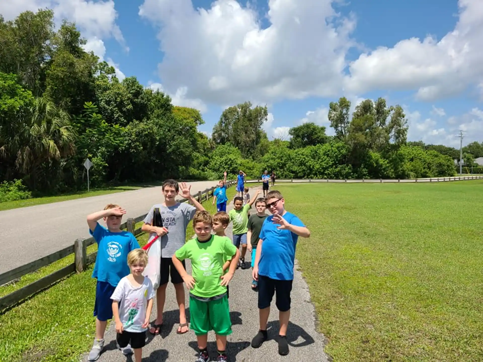 a group of people running on a path in a park