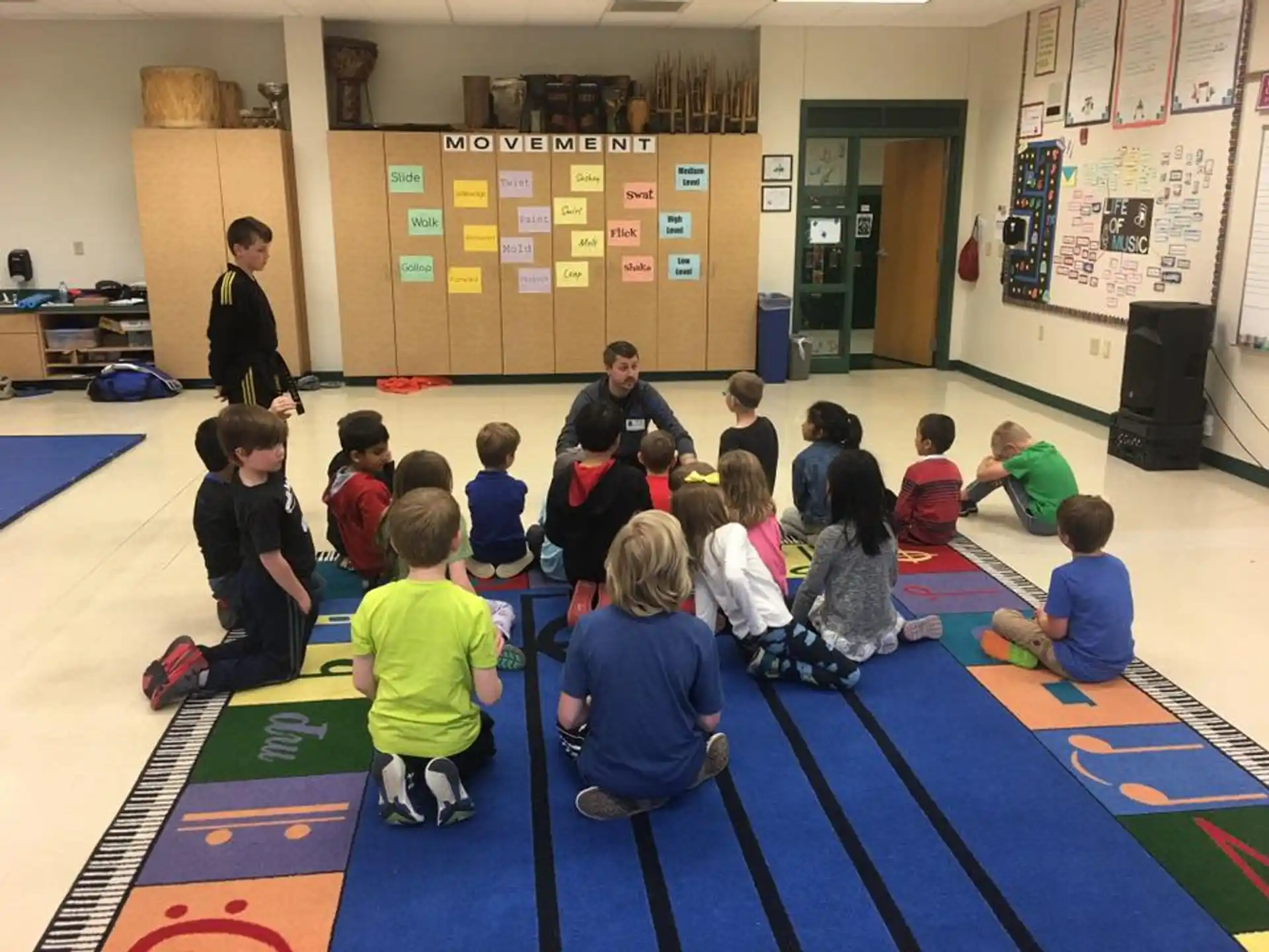 a group of children sitting on the floor in a classroom