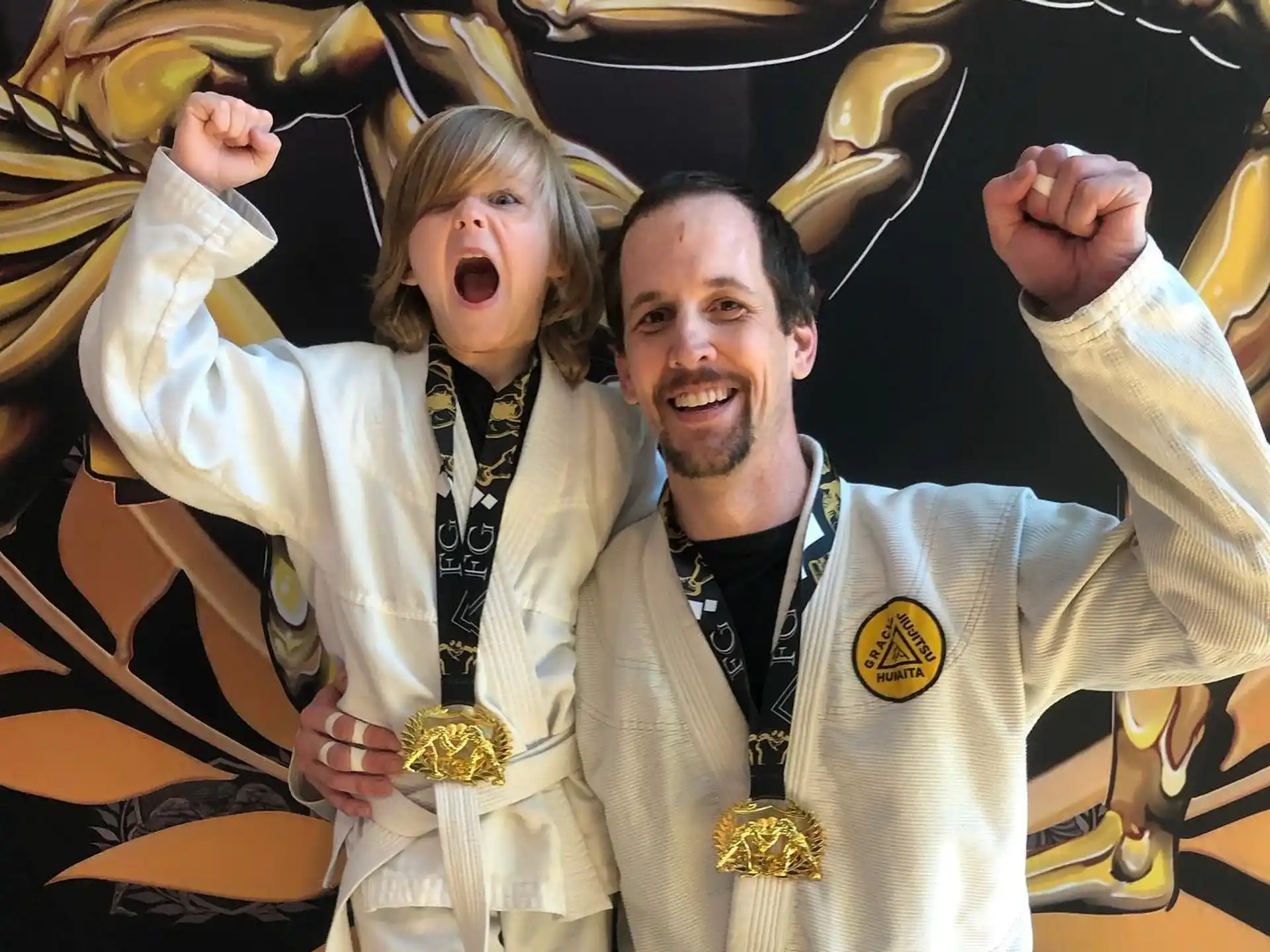 a man and woman wearing gold medals