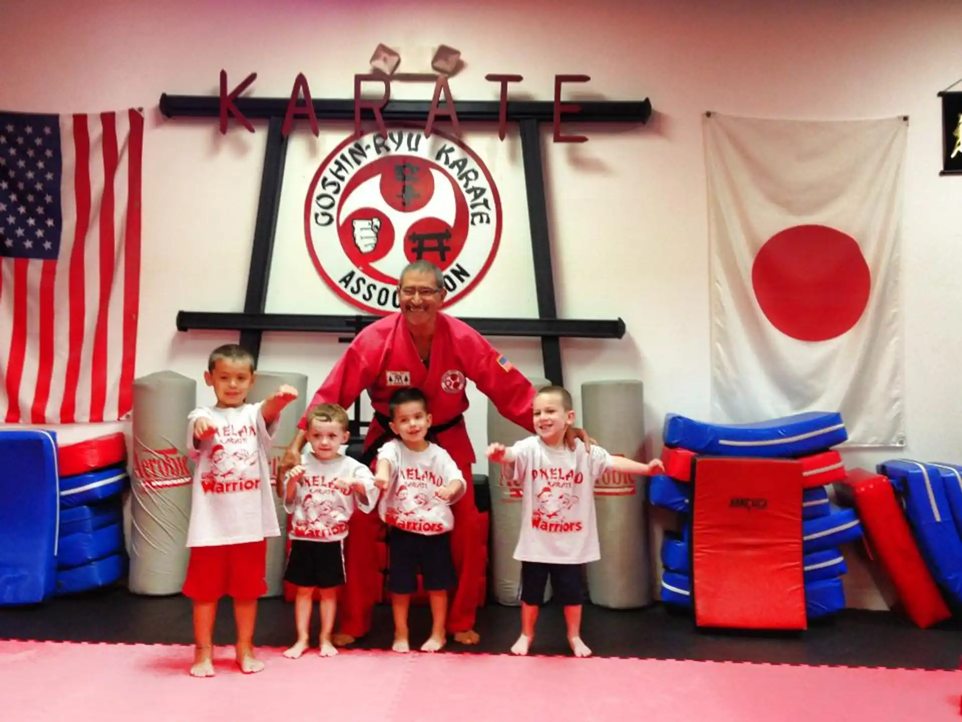 a group of kids posing for a photo in front of a large red and white sign