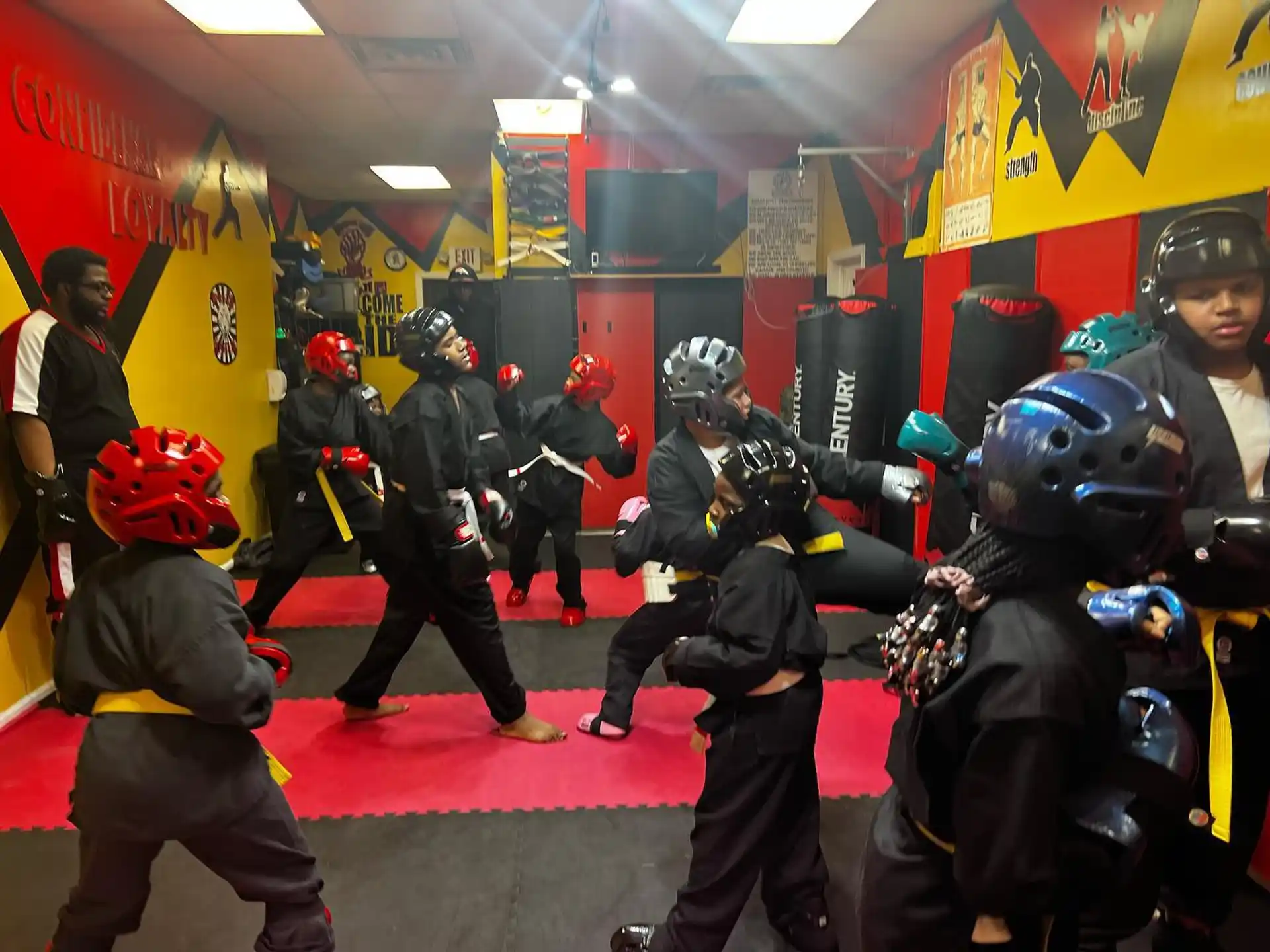 a group of people in black and red helmets in a room with a red carpet and a yellow