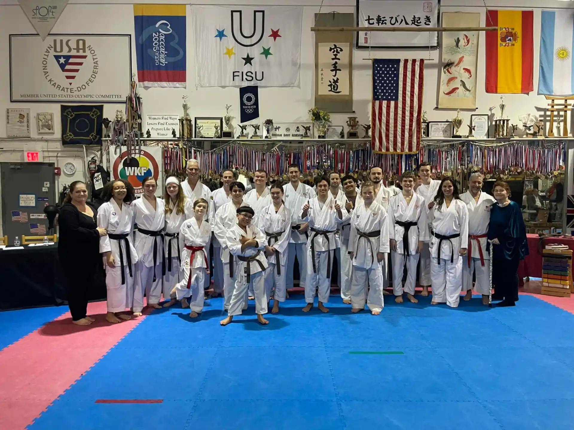 a group of people in white karate uniforms standing on a red carpet