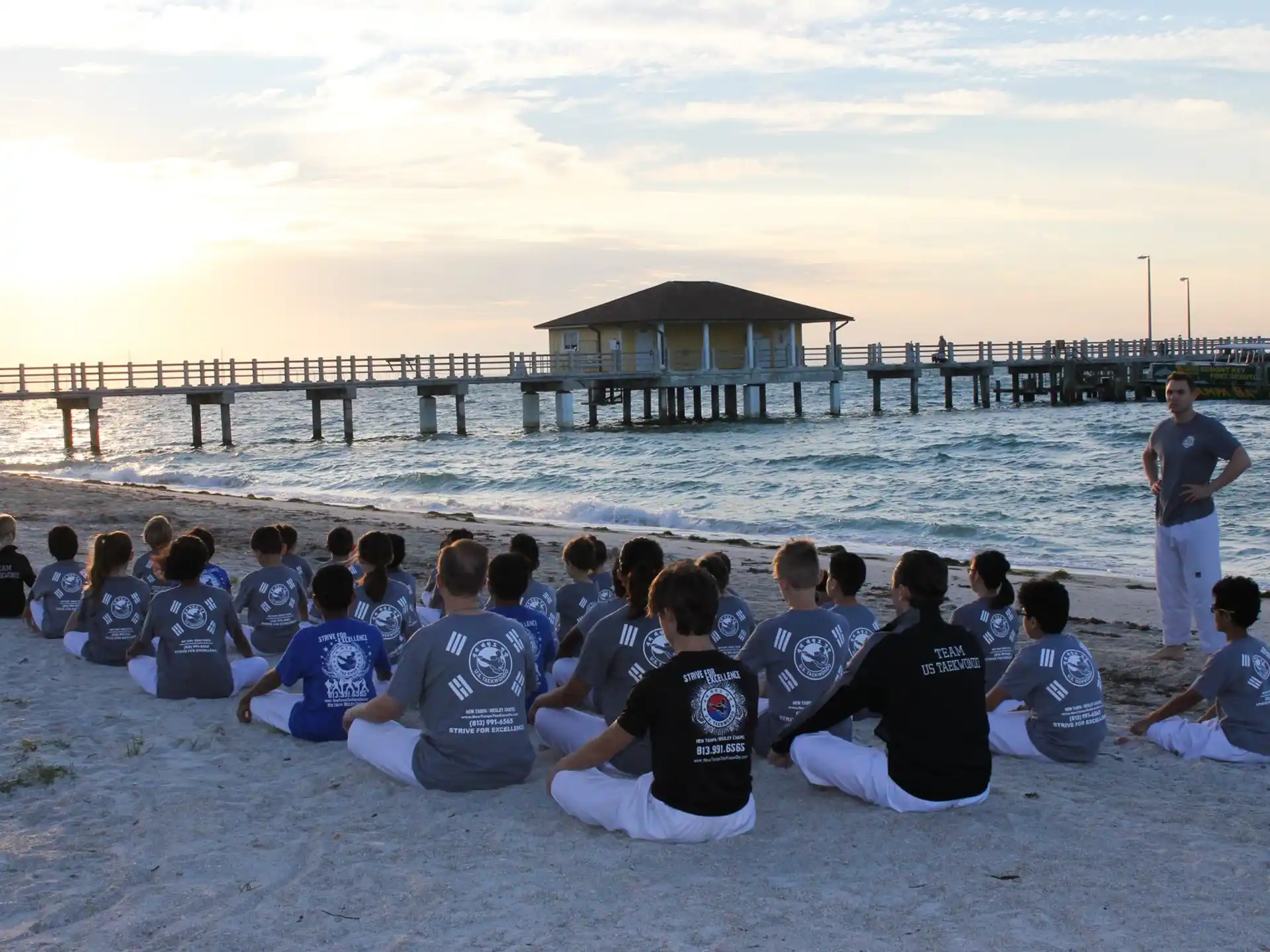 a group of people sitting on the beach
