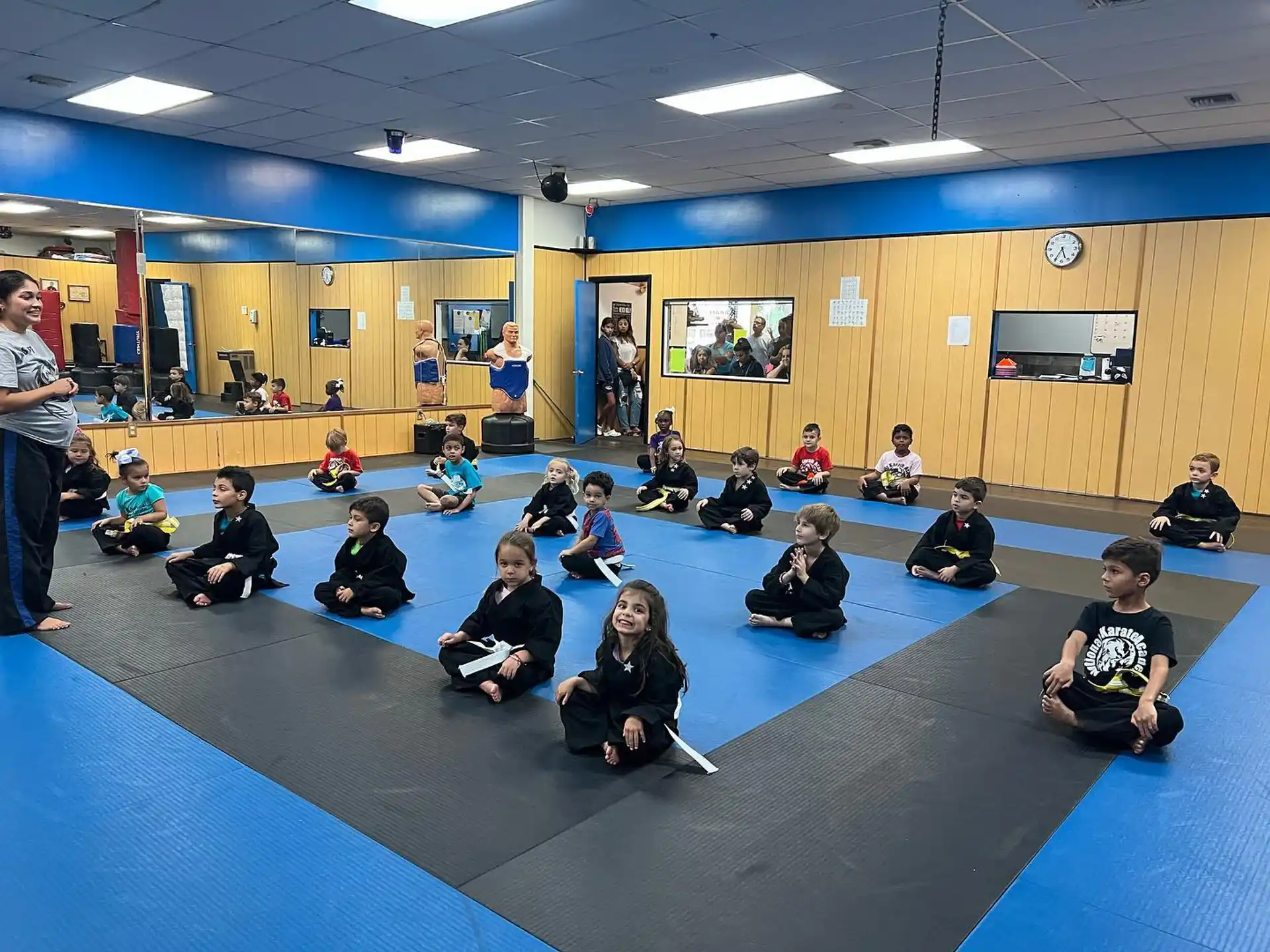 a group of people sitting on a mat in a room