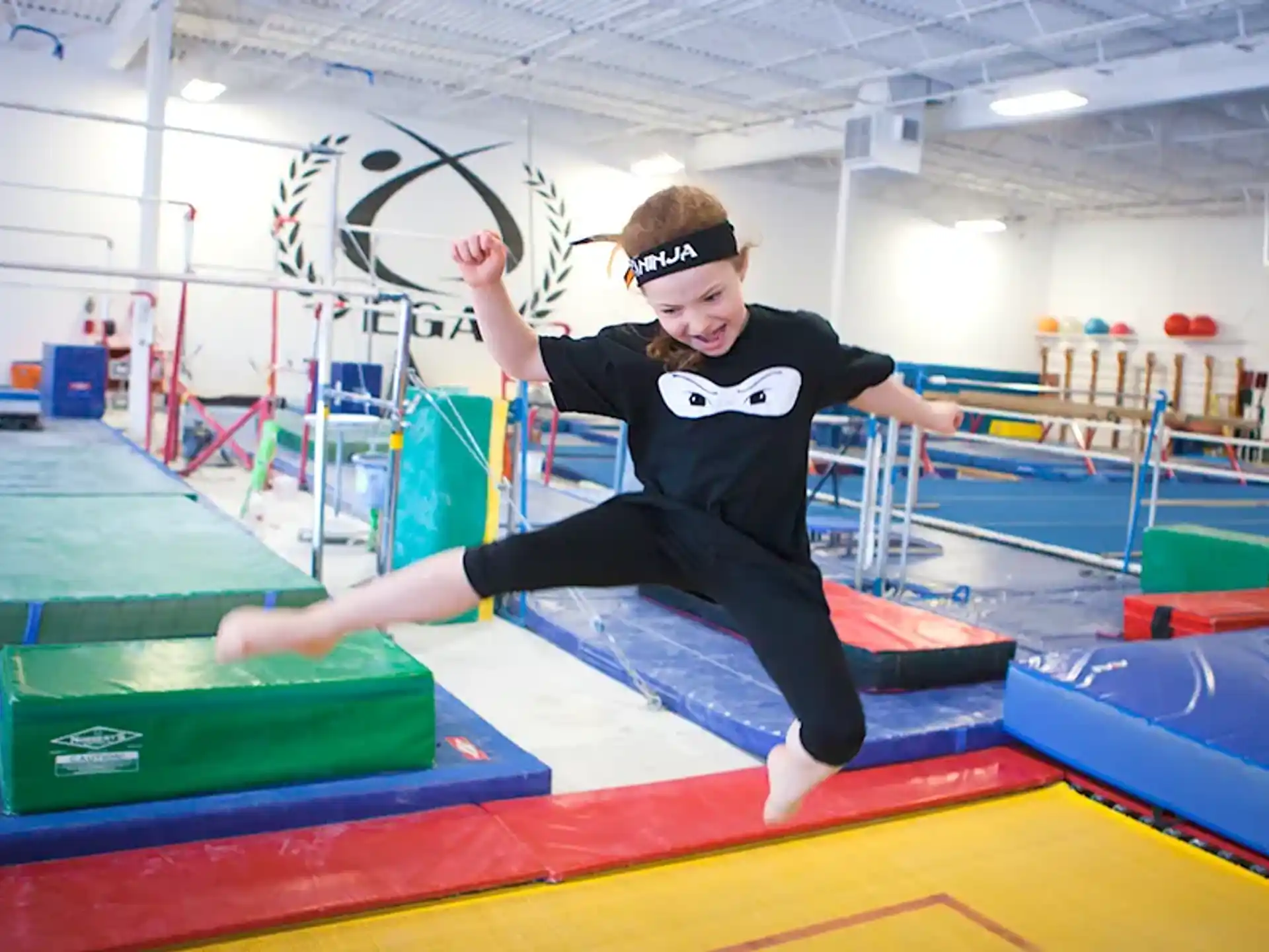 a boy jumping on a trampoline