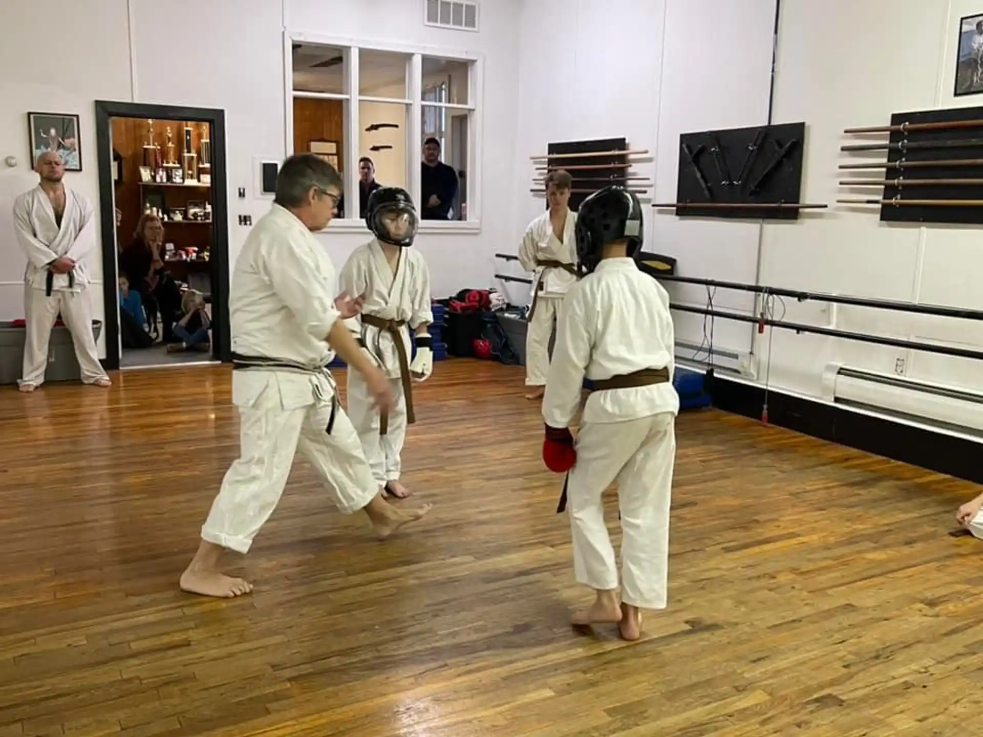 a group of people in white karate uniforms in a room