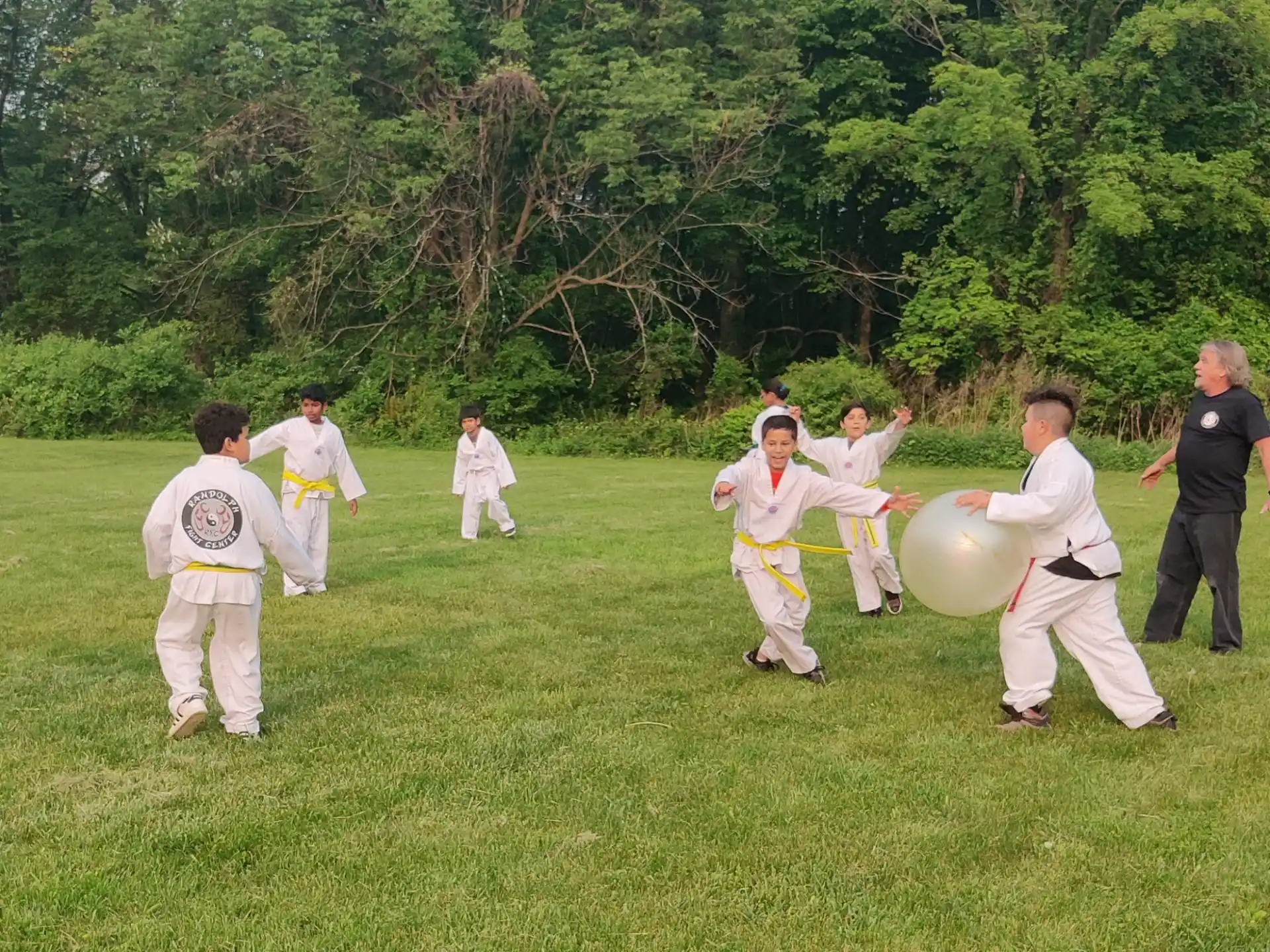 a group of people in white karate uniforms holding large white balls