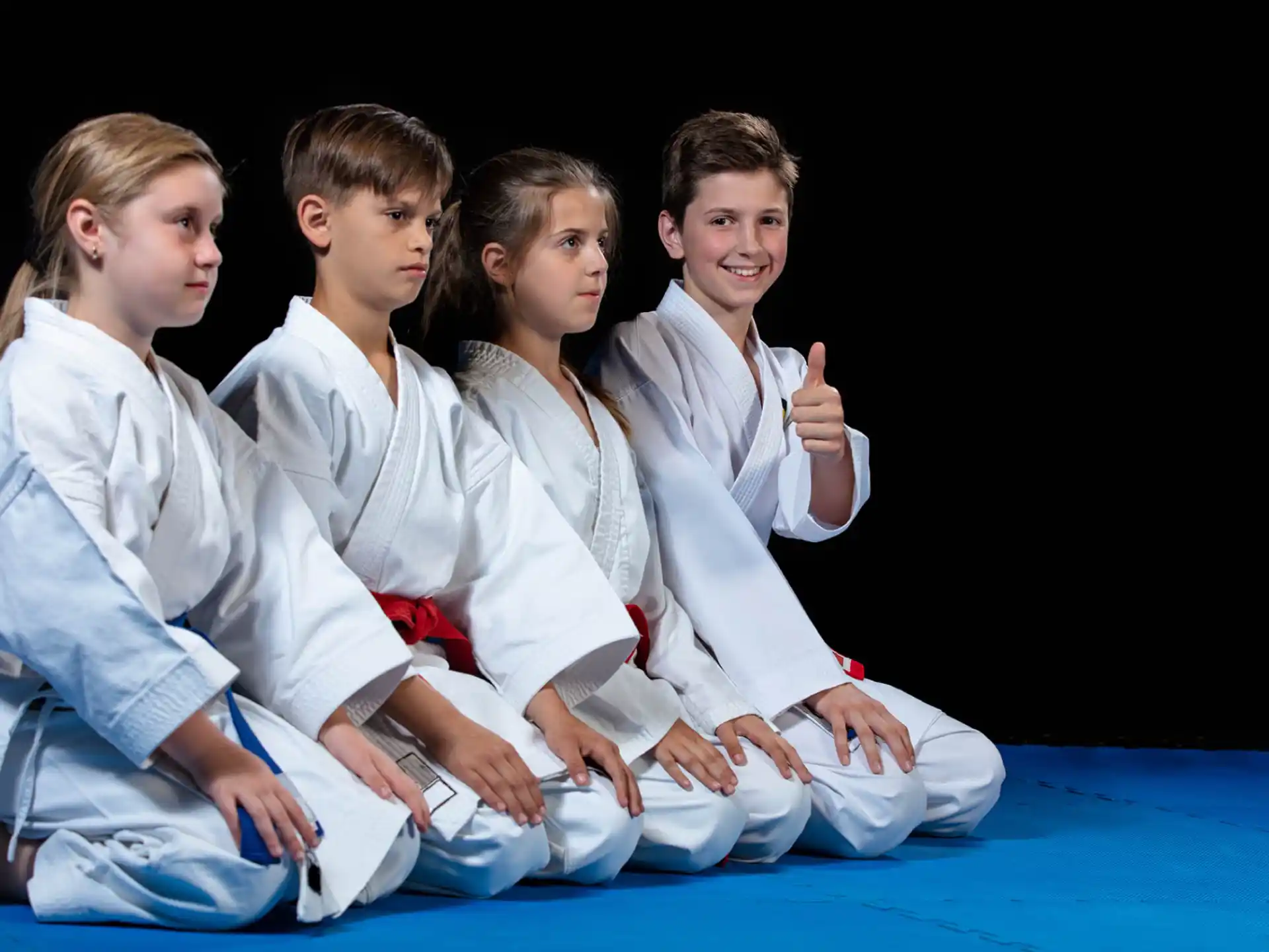 a group of people in white karate uniforms