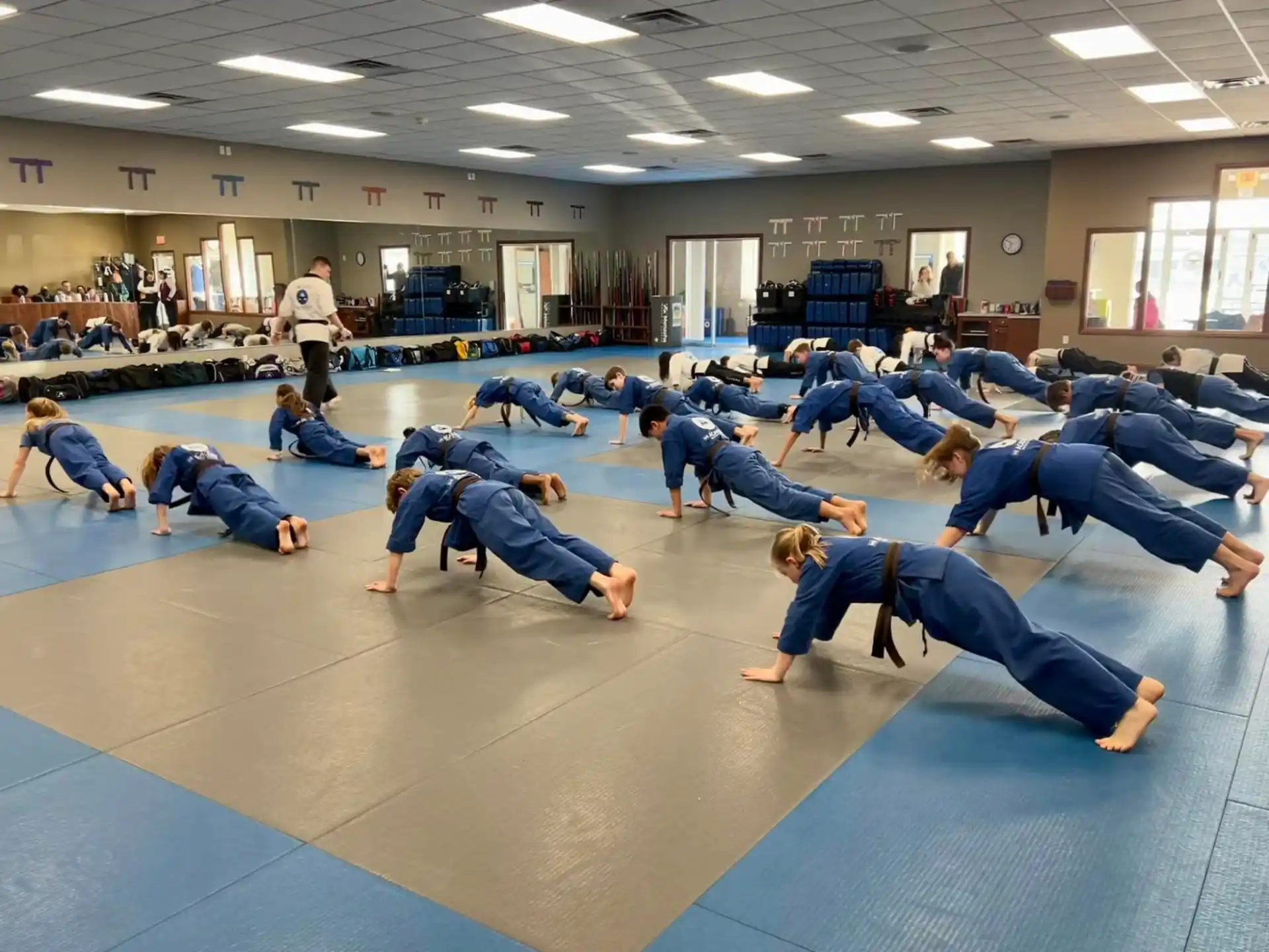 a group of people in blue karate uniforms on a blue mat