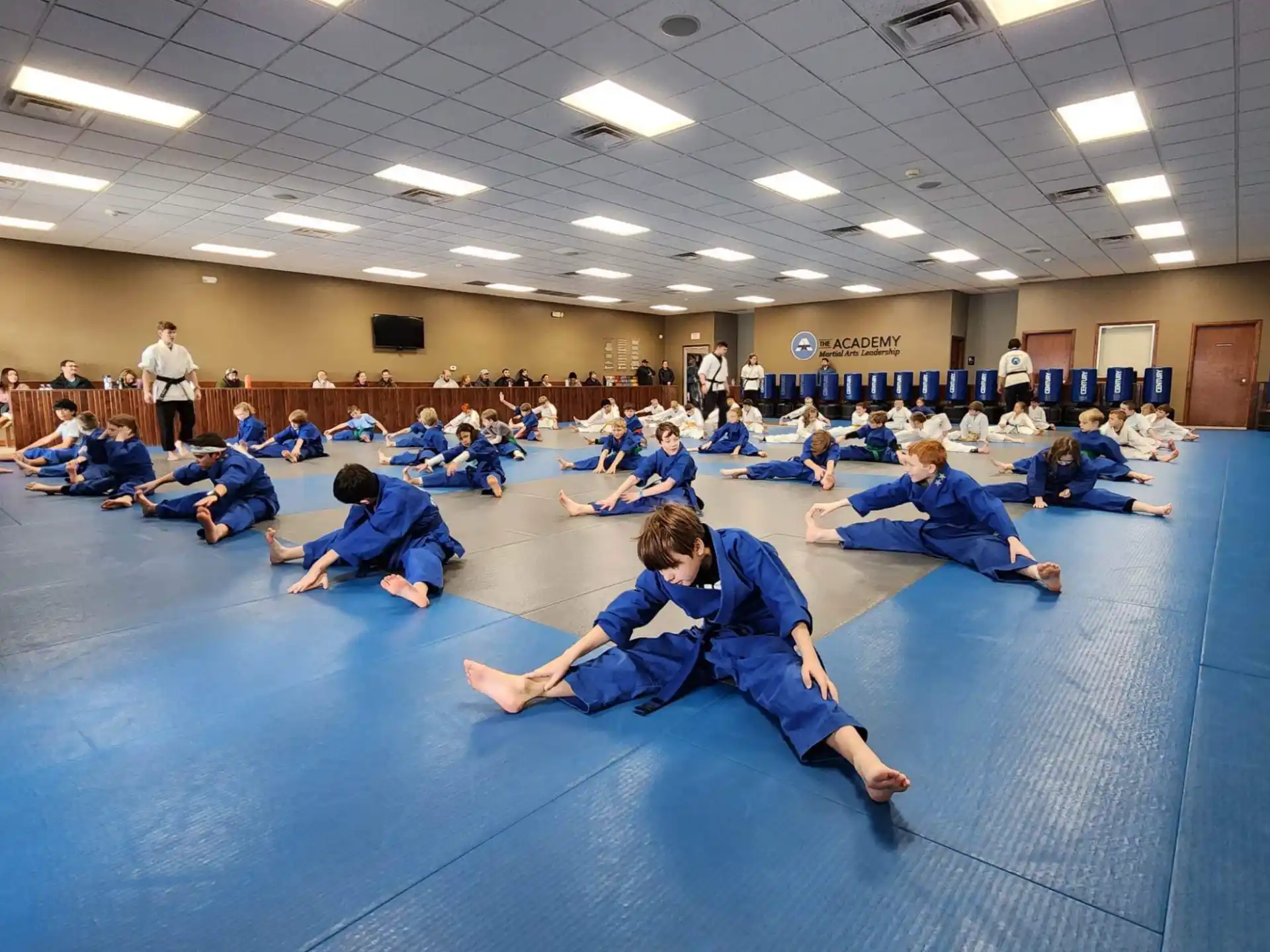 a group of people in blue karate uniforms on a blue mat