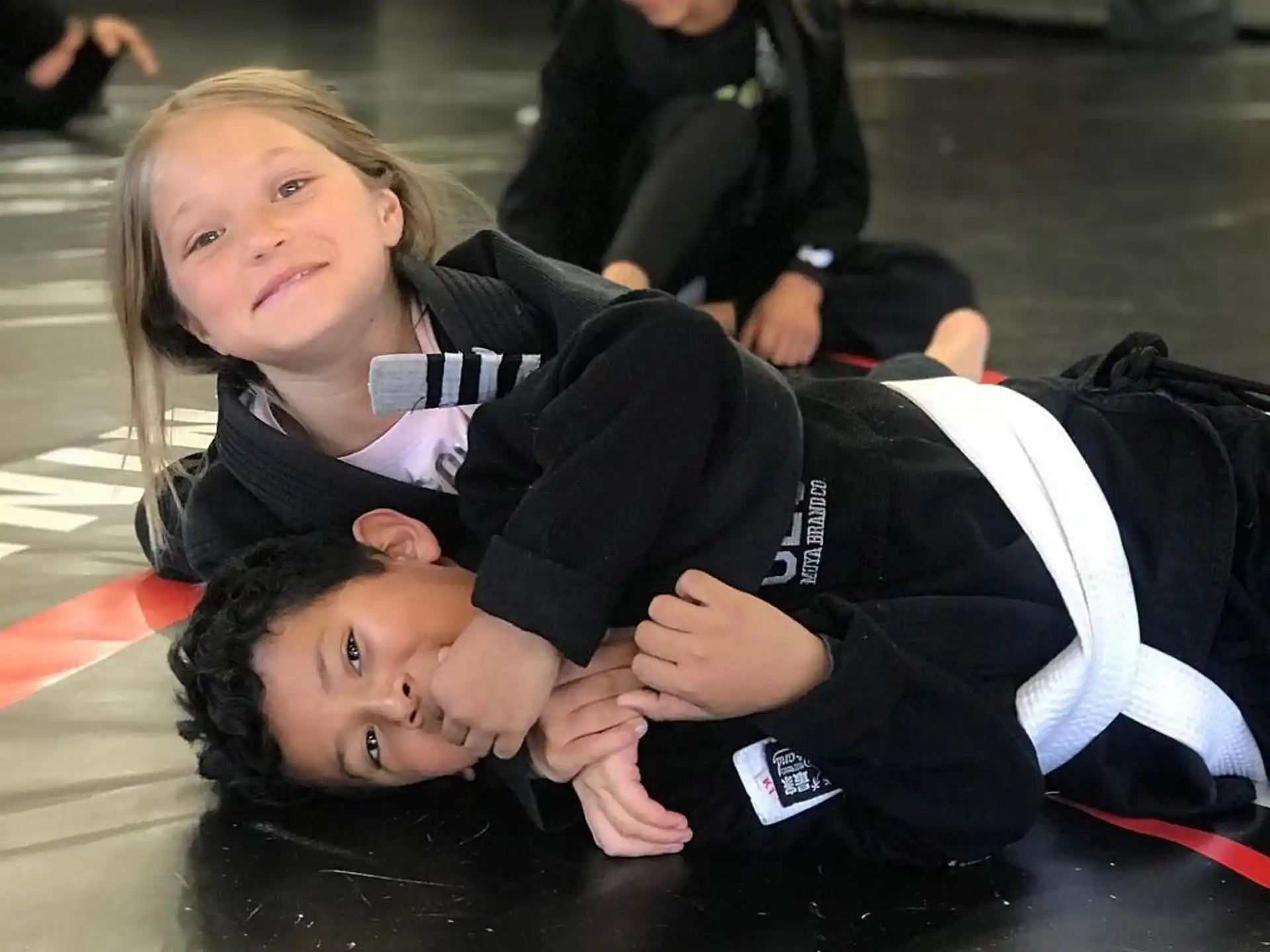 a couple of children lying on the ground posing for the camera