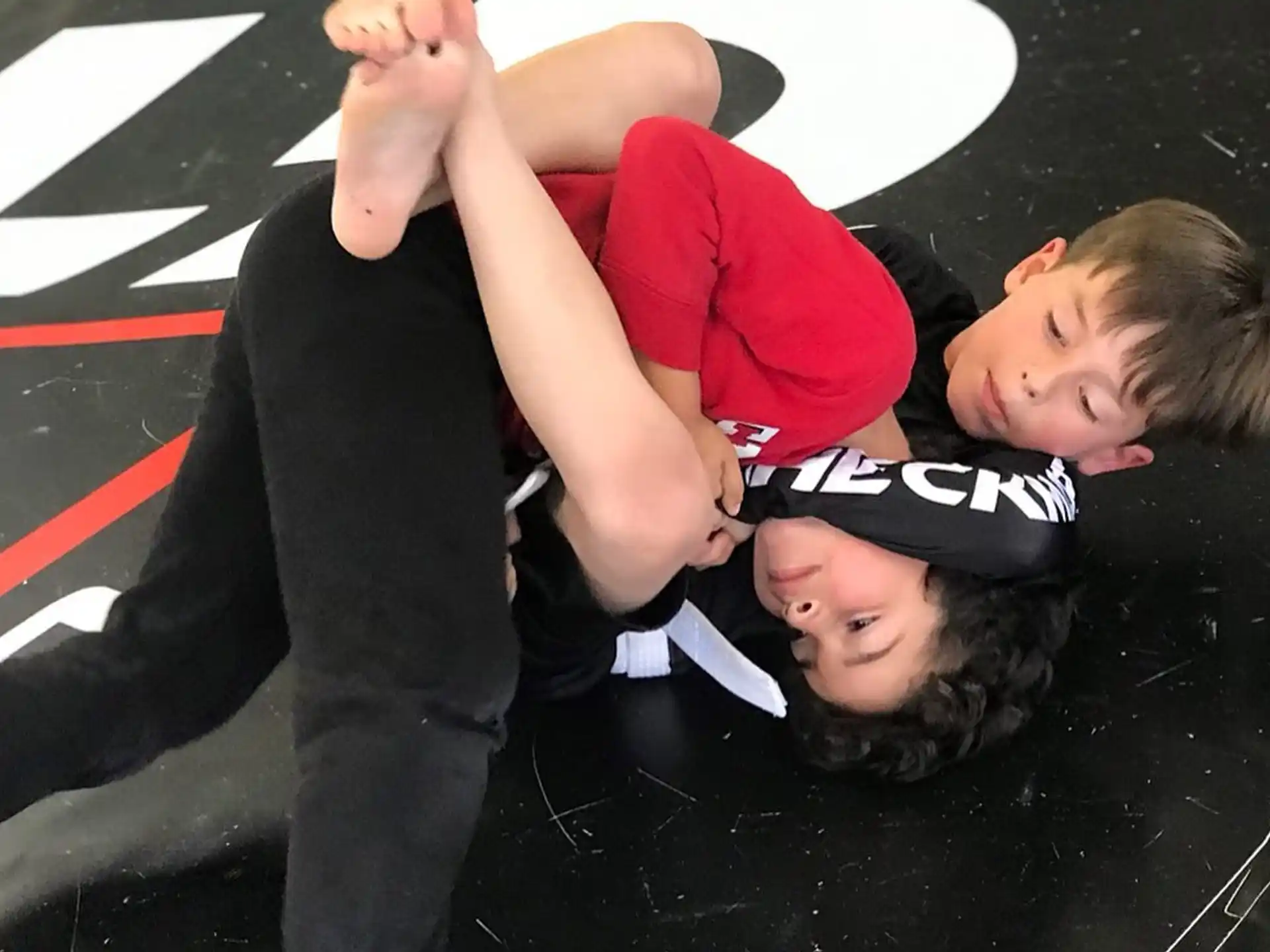 a group of children lying on a black and red striped floor