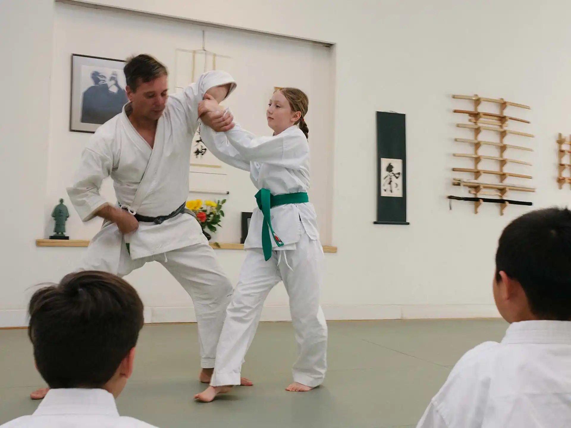 a man and a woman in karate uniforms in a room with other people