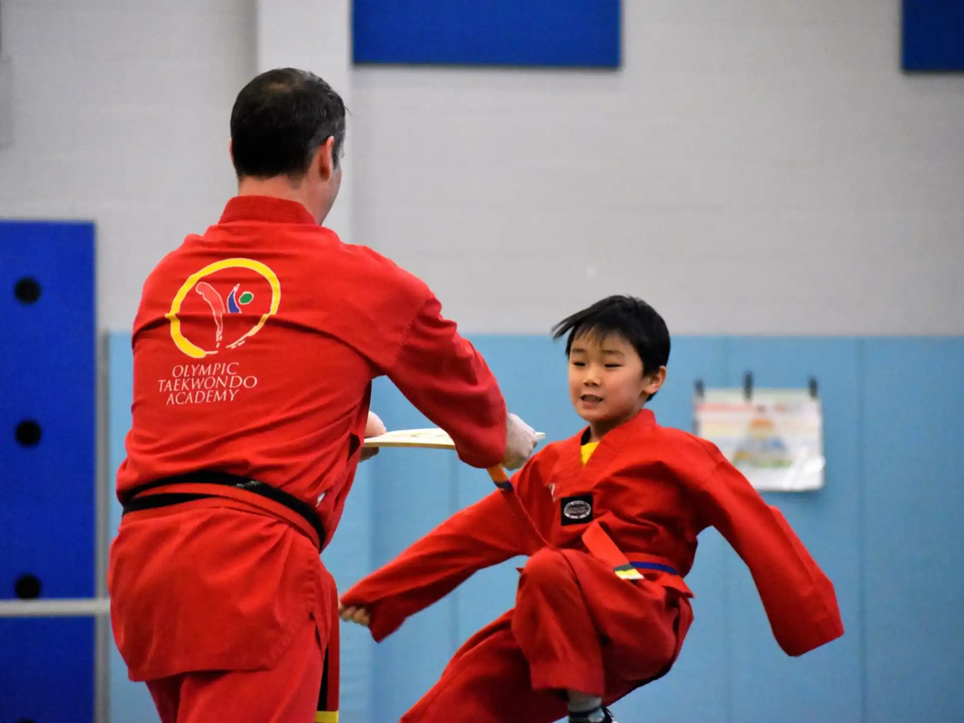 a man and a boy in red uniforms in a room