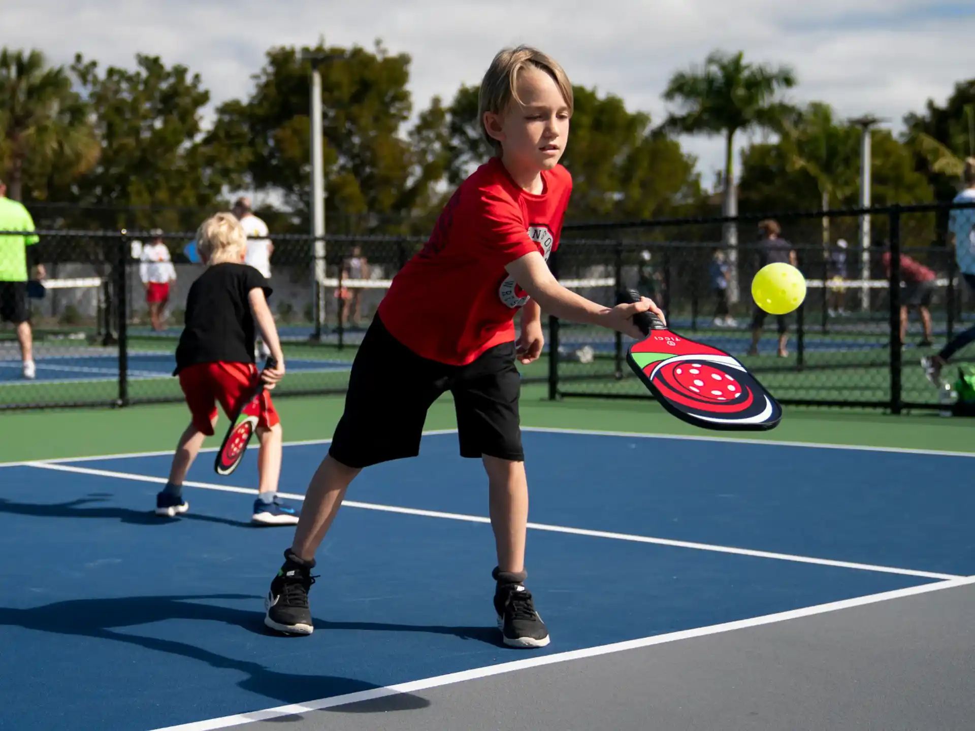 a boy hitting a ball with a racket