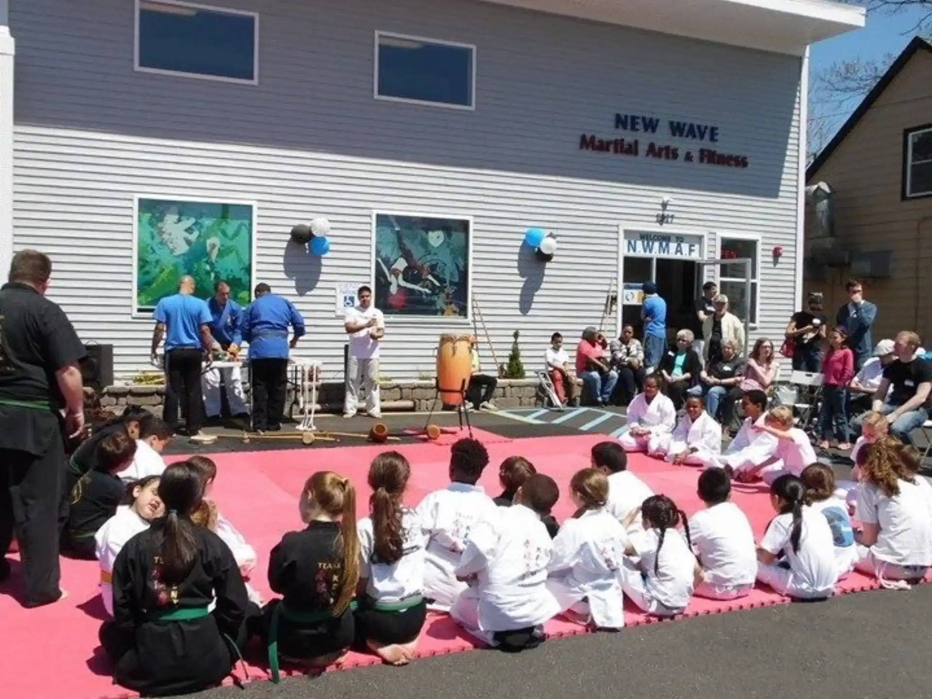 a group of people sitting on the ground in front of a building