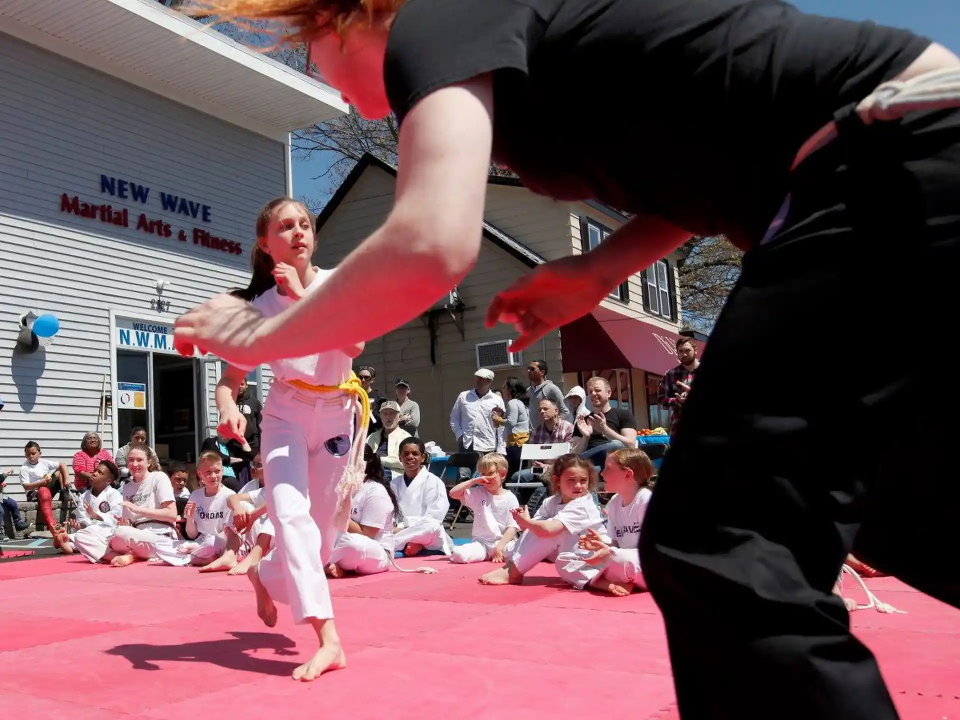 a man and woman in a martial arts ring with a crowd watching