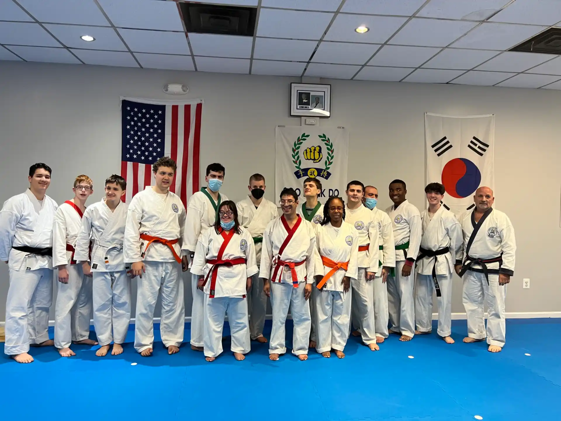 a group of people in white karate uniforms posing for a photo