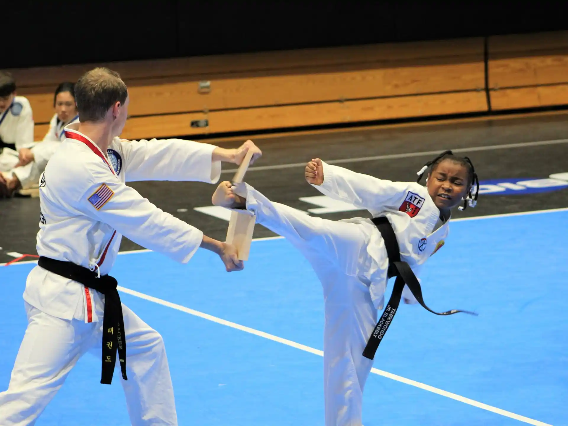 a man and a woman in karate uniforms with their hands up