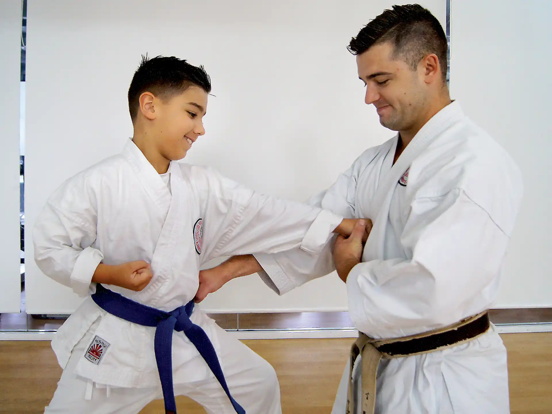 a man in a karate uniform shaking hands with another man in a white uniform
