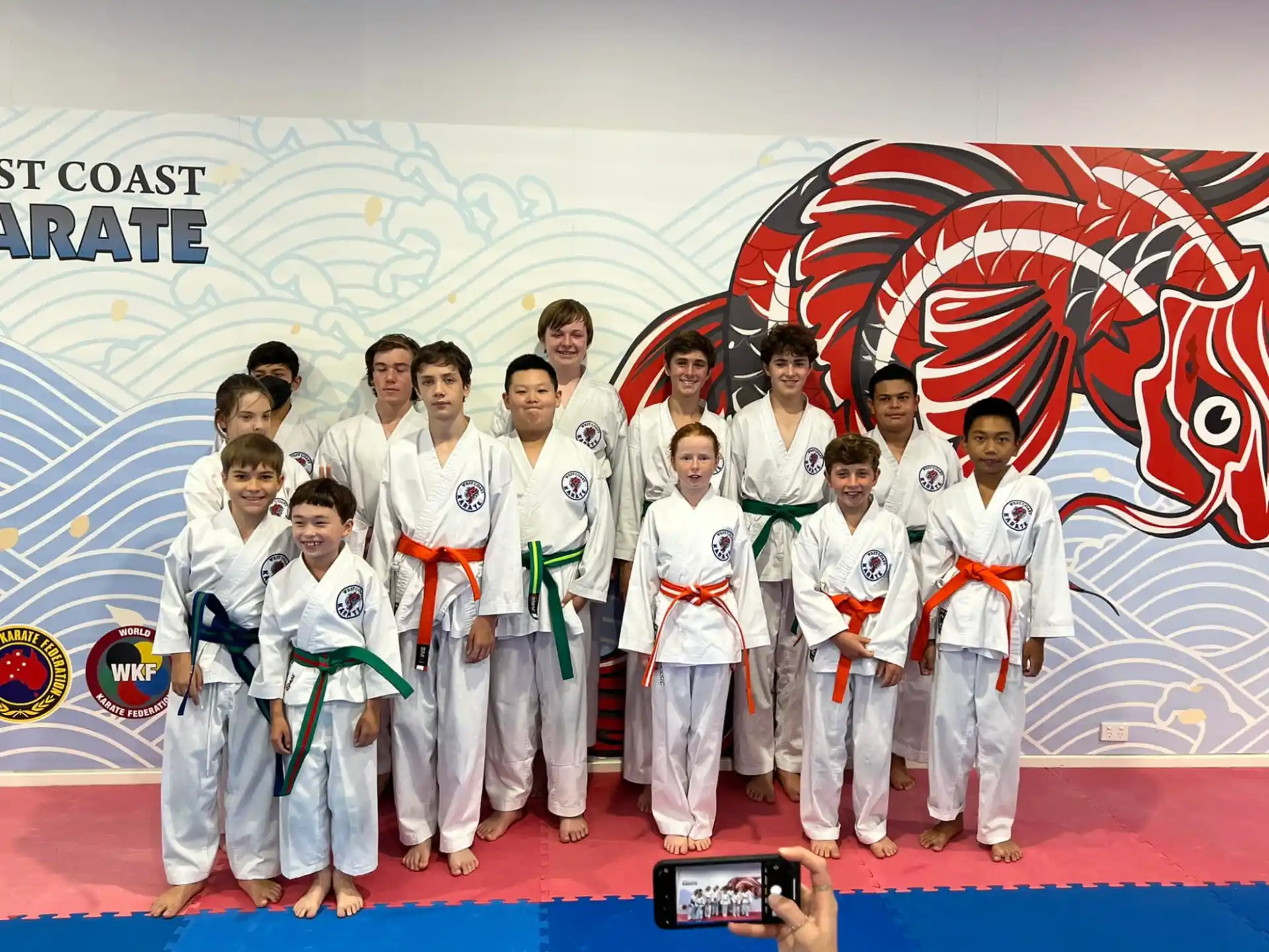 a group of people in white karate uniforms posing for a photo