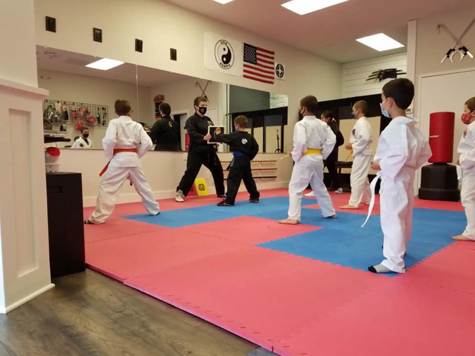 a group of people in white karate uniforms in a room