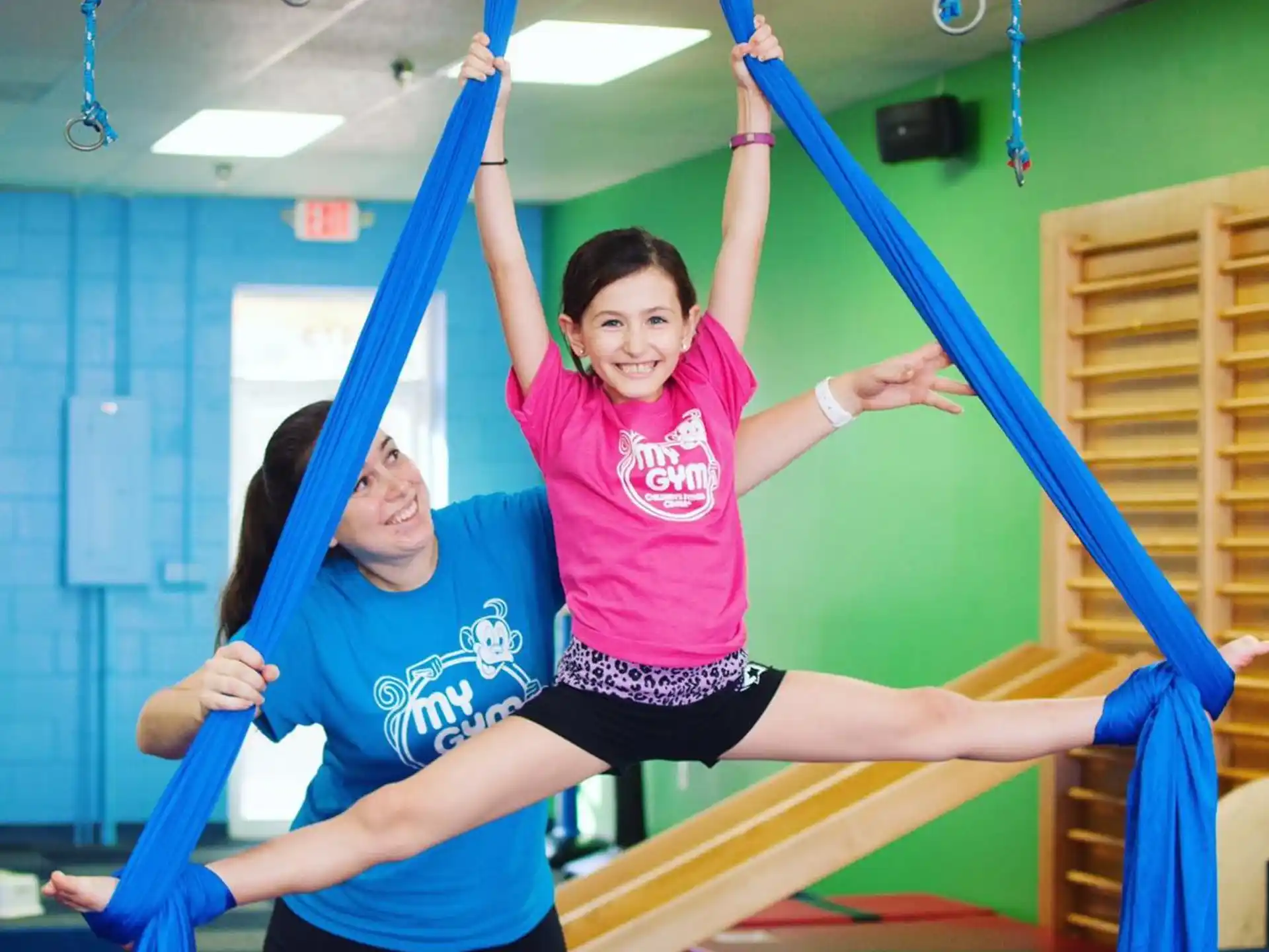 a couple of girls playing on a gym