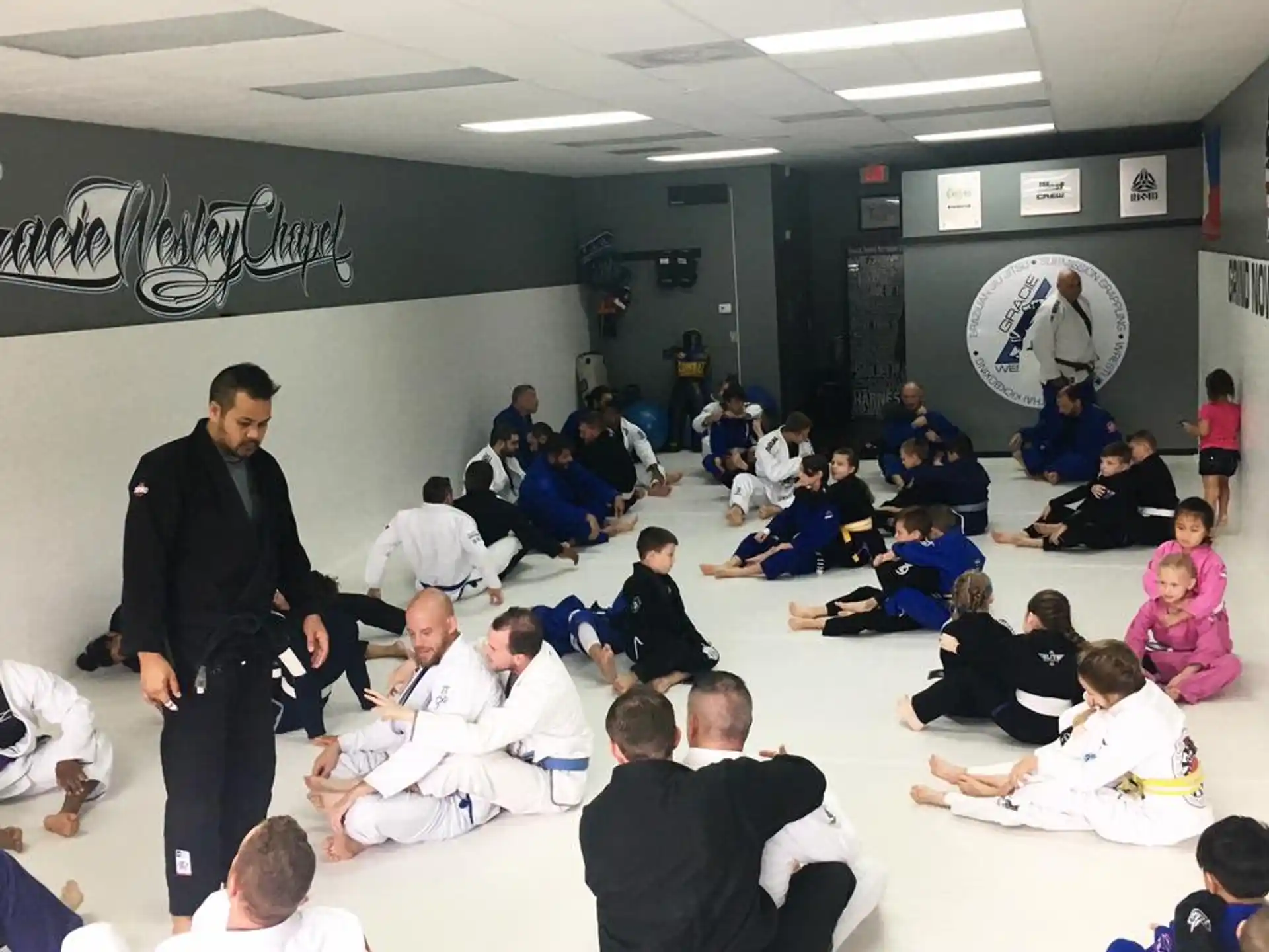 a person standing in front of a group of people sitting on the floor